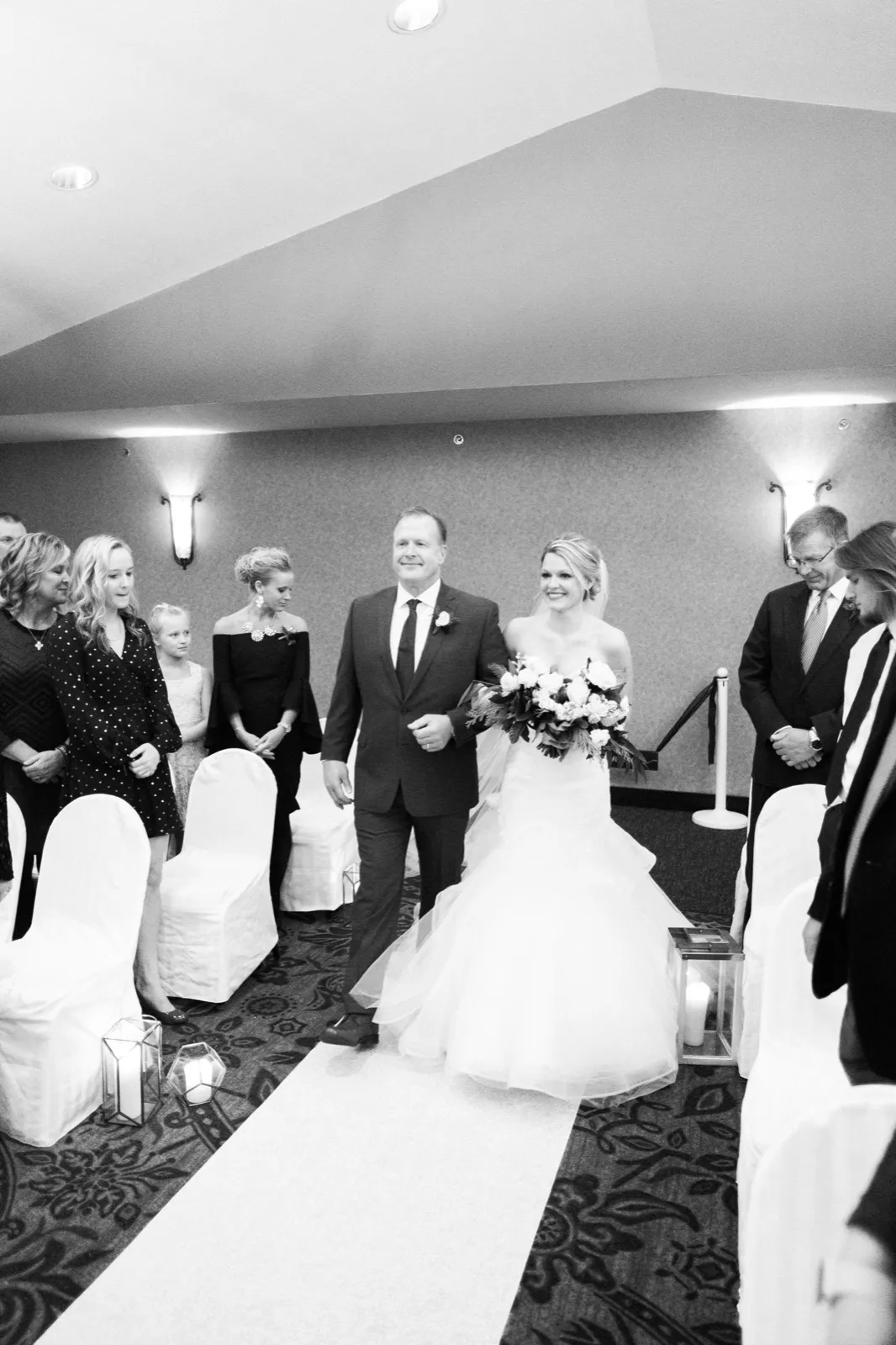Morgan and her father smile as they walk down the ceremony aisle at Breezy Point Resort