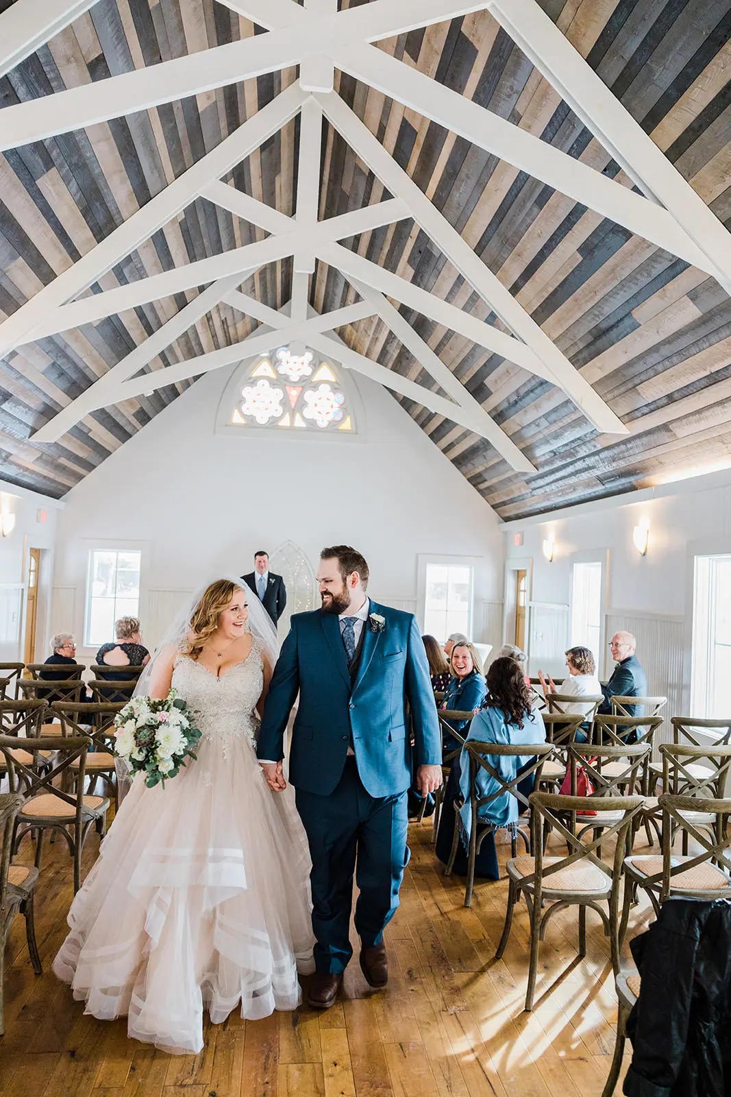 Walking back up the aisle as husband and wife — reclaimed wood ceiling and white trusses at The Chapel — Tim Larsen Photography, Brainerd Lakes MN