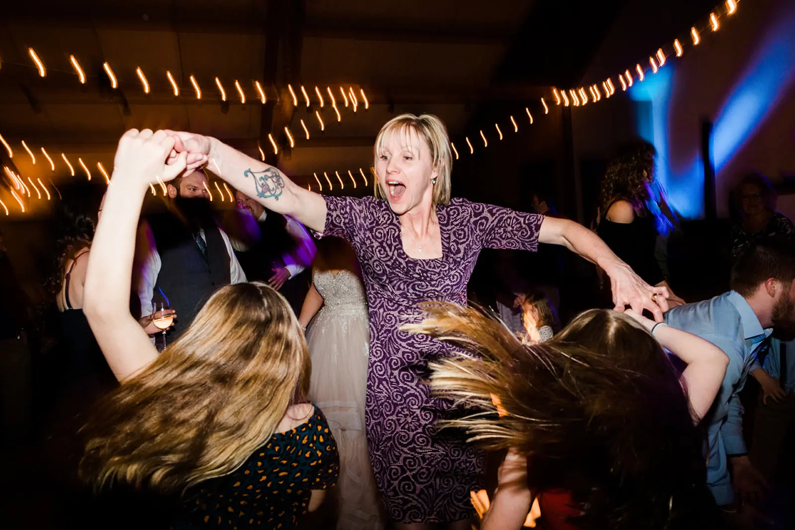 Dance floor energy — guest spinning under purple and blue lights — Tim Larsen Photography, Brainerd Lakes MN
