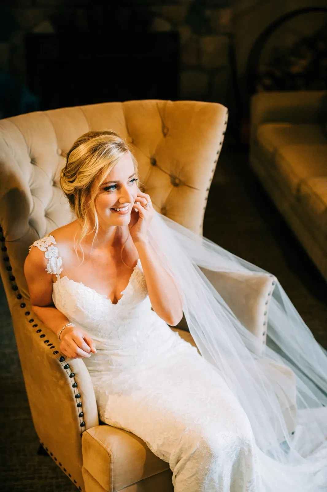 Shannon in a tufted velvet chair near a stone fireplace, lit by soft window light at Madden's on Gull Lake — Tim Larsen Photography, Brainerd Lakes MN