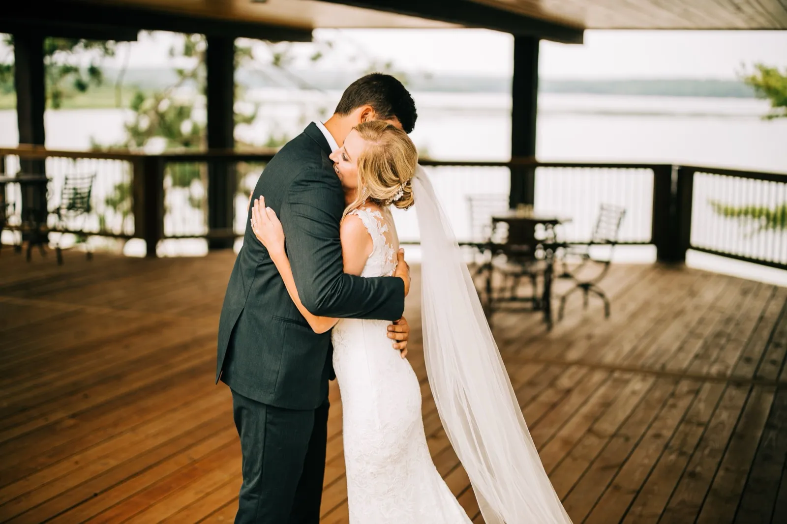 Shannon and Zach embrace on the covered porch after their first look, Gull Lake quiet behind them — Tim Larsen Photography, Brainerd Lakes MN
