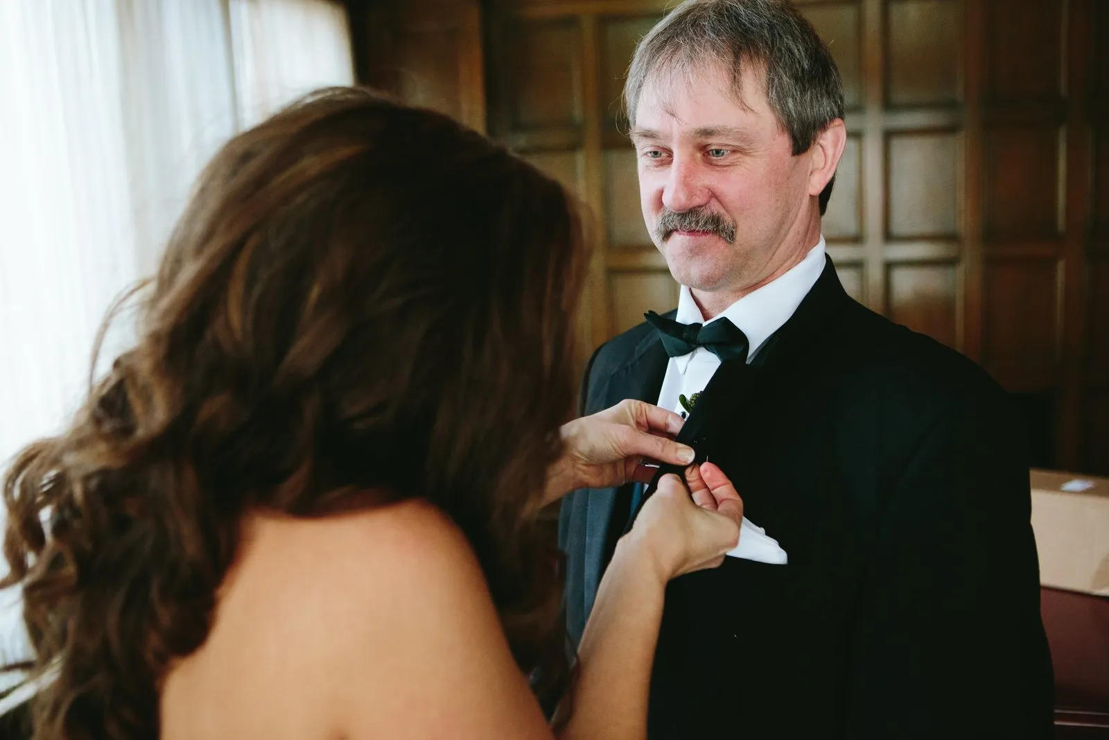Bride pinning her father's boutonniere, his expression caught mid-emotion — Greysolon Plaza, just before the ceremony — Tim Larsen Photography, Duluth MN