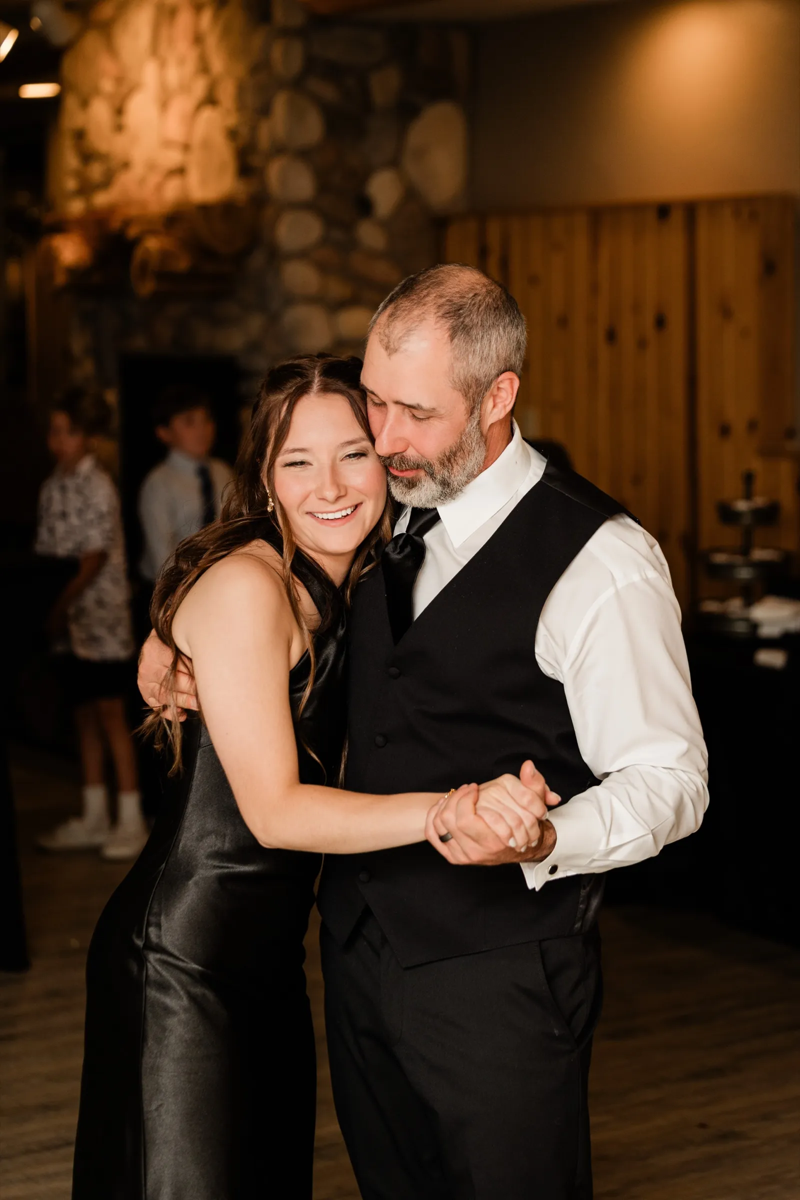 Don shares a dance with his daughter in front of the stone fireplace in the Whitefish Lodge banquet room — Tim Larsen Photography, Brainerd Lakes MN