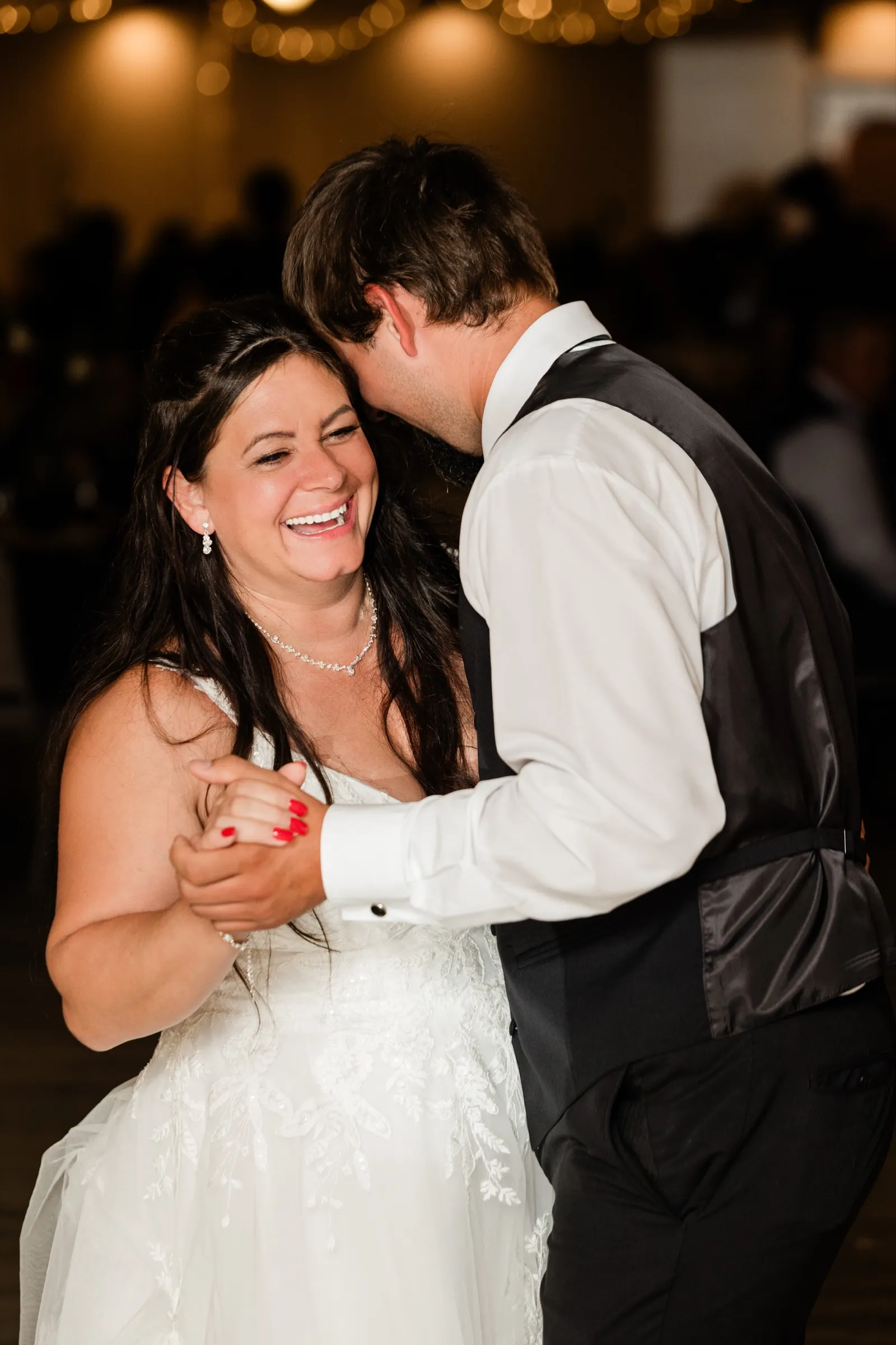 Amber laughs as she dances with her son under the string lights at the reception — Tim Larsen Photography, Brainerd Lakes MN
