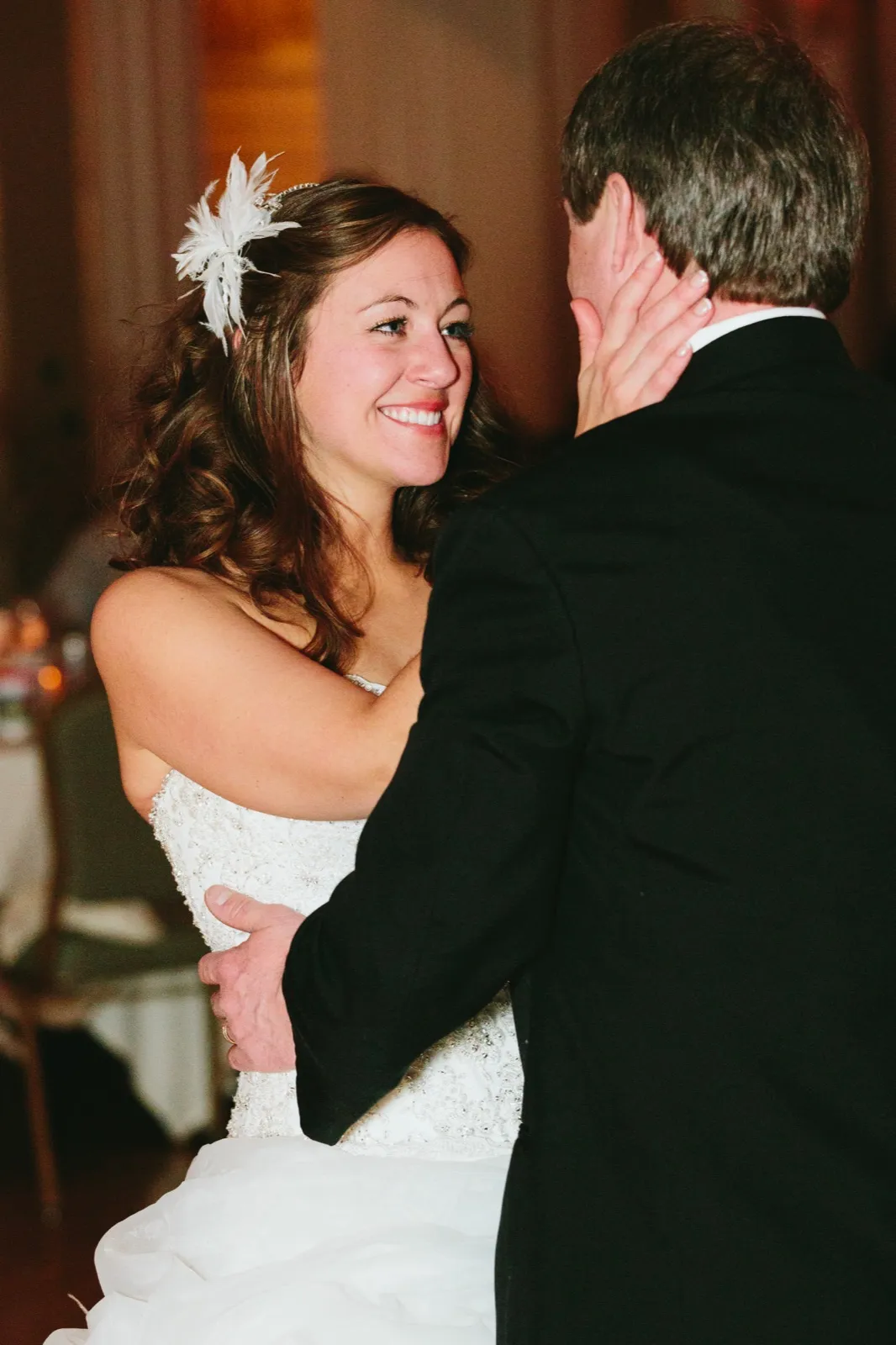Bride's radiant gaze at the groom mid-first-dance, her hand cradling his face — Greysolon Ballroom — Tim Larsen Photography, Duluth MN