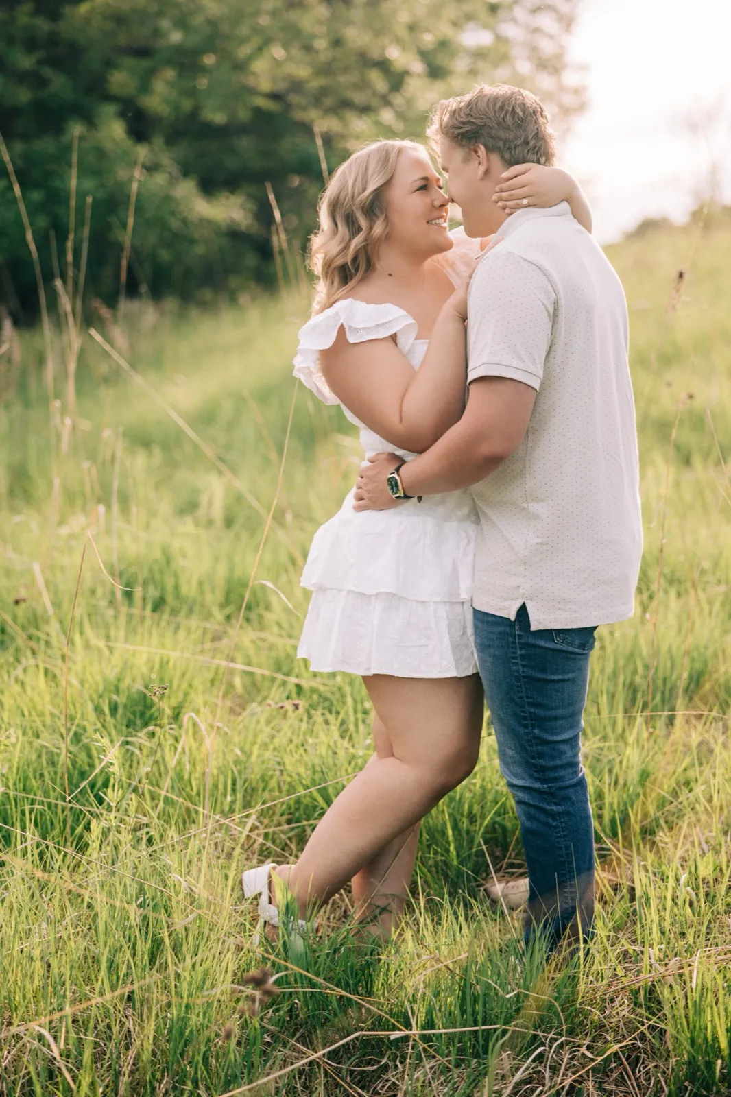 Abby leans back with a laugh in Anthony's arms in the tall grass at Carver Park — Tim Larsen Photography