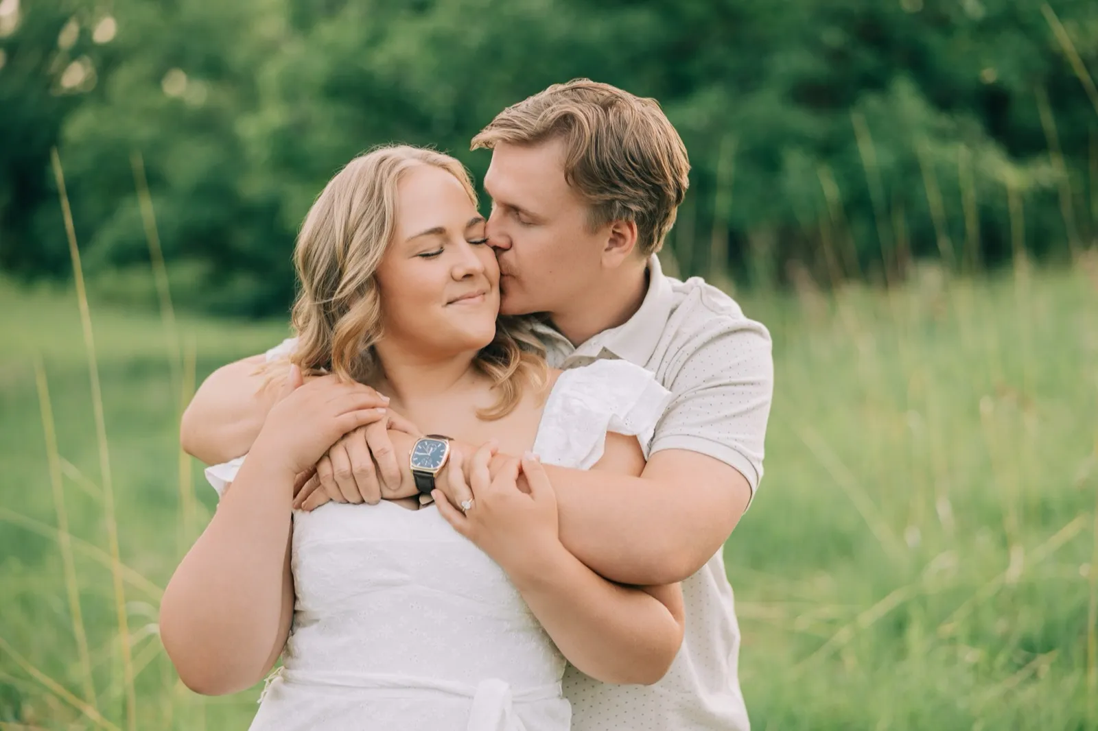 Anthony wraps his arms around Abby from behind and kisses her cheek, her engagement ring resting on his arm — Tim Larsen Photography