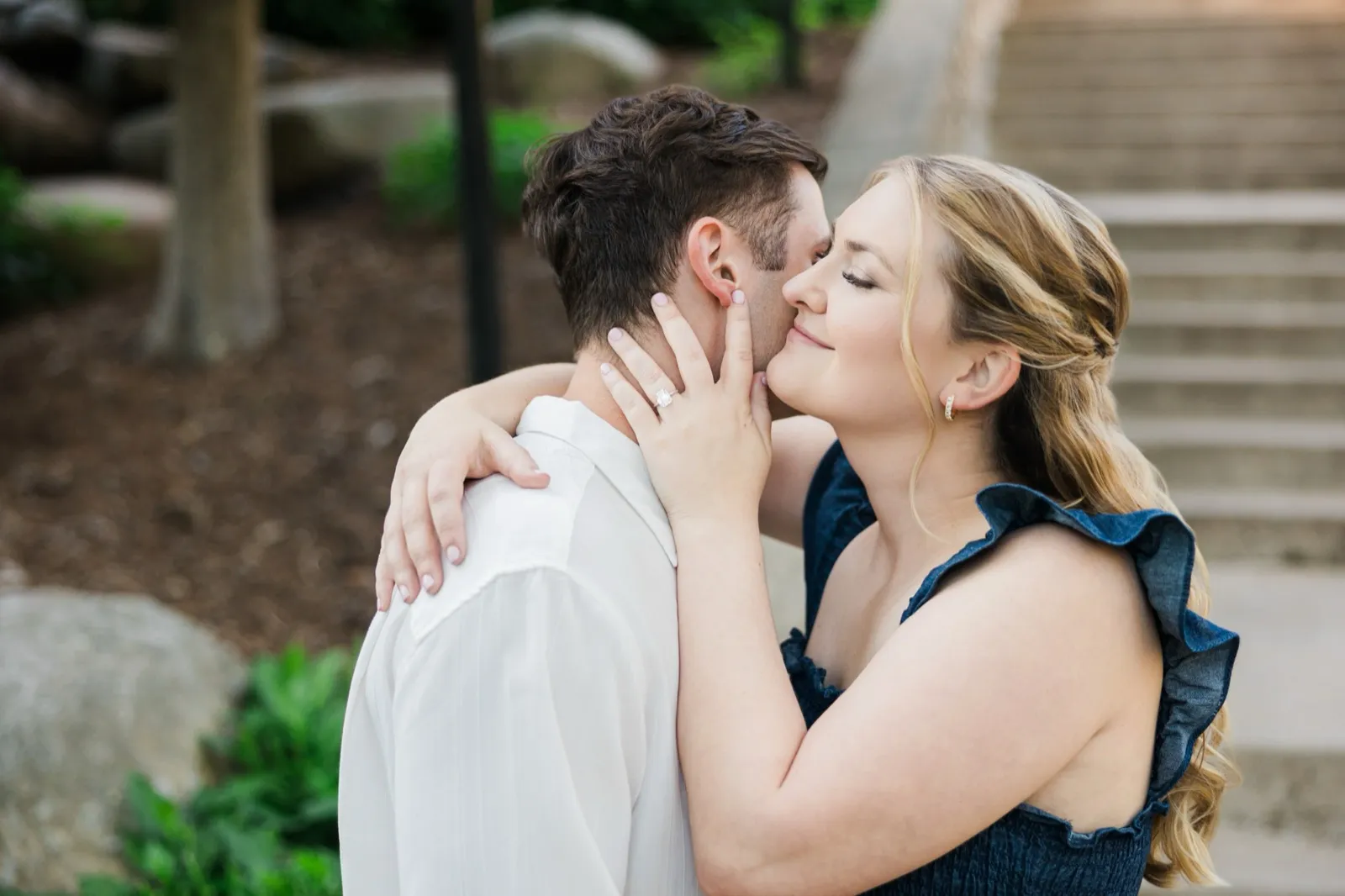 A woman cradles her fiance's face with her ringed hand, eyes closed, in a tender near-kiss — Tim Larsen Photography