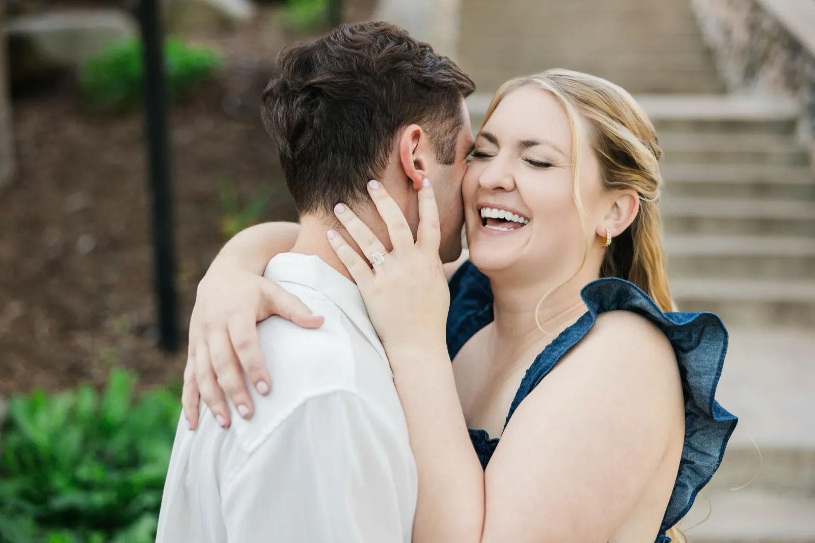 A woman laughs with her head thrown back while embracing her fiance, her engagement ring visible at his neck — Tim Larsen Photography