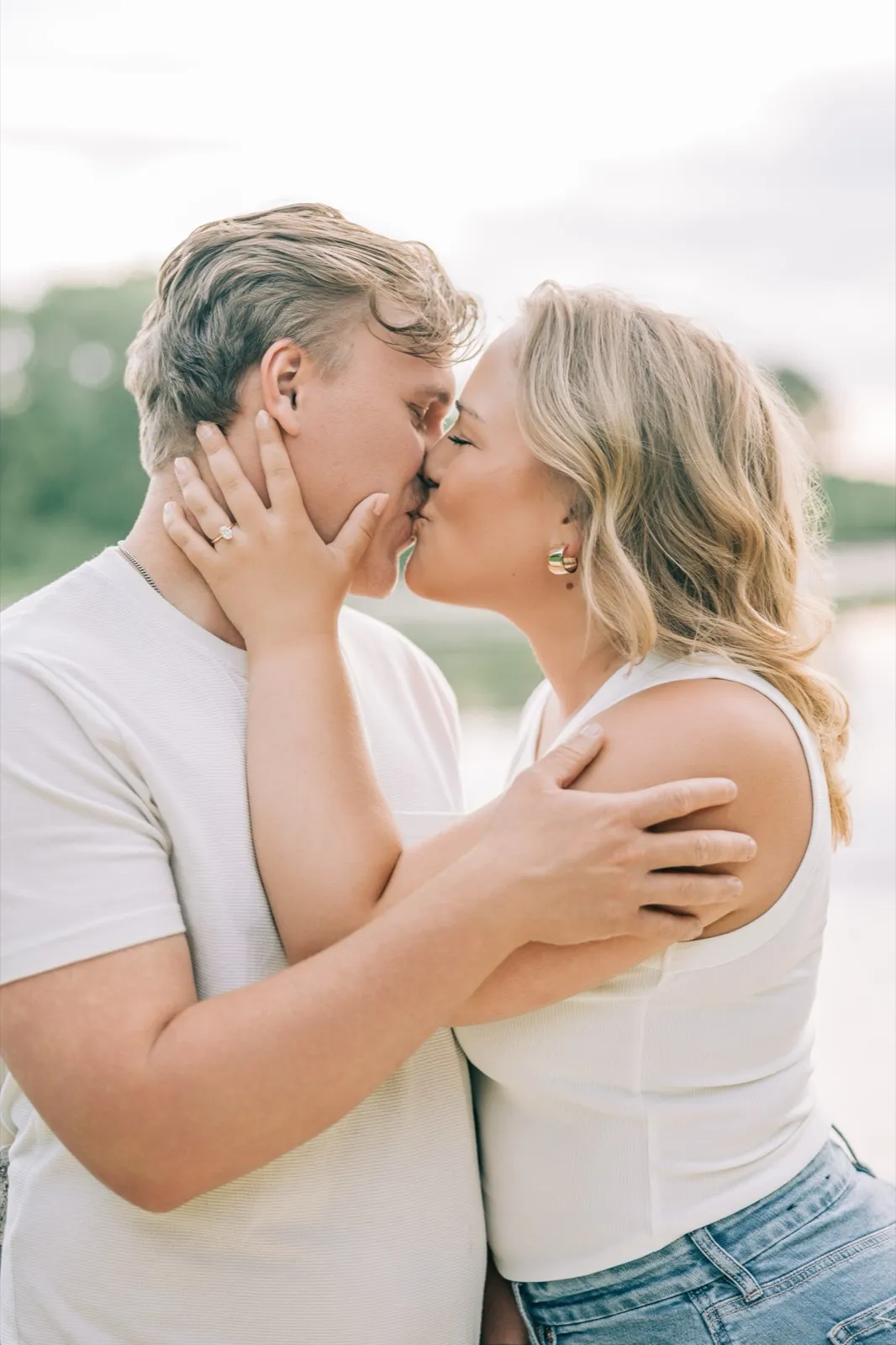Abby kisses Anthony on the dock, her hand cradling his jaw and her engagement ring in frame — Tim Larsen Photography