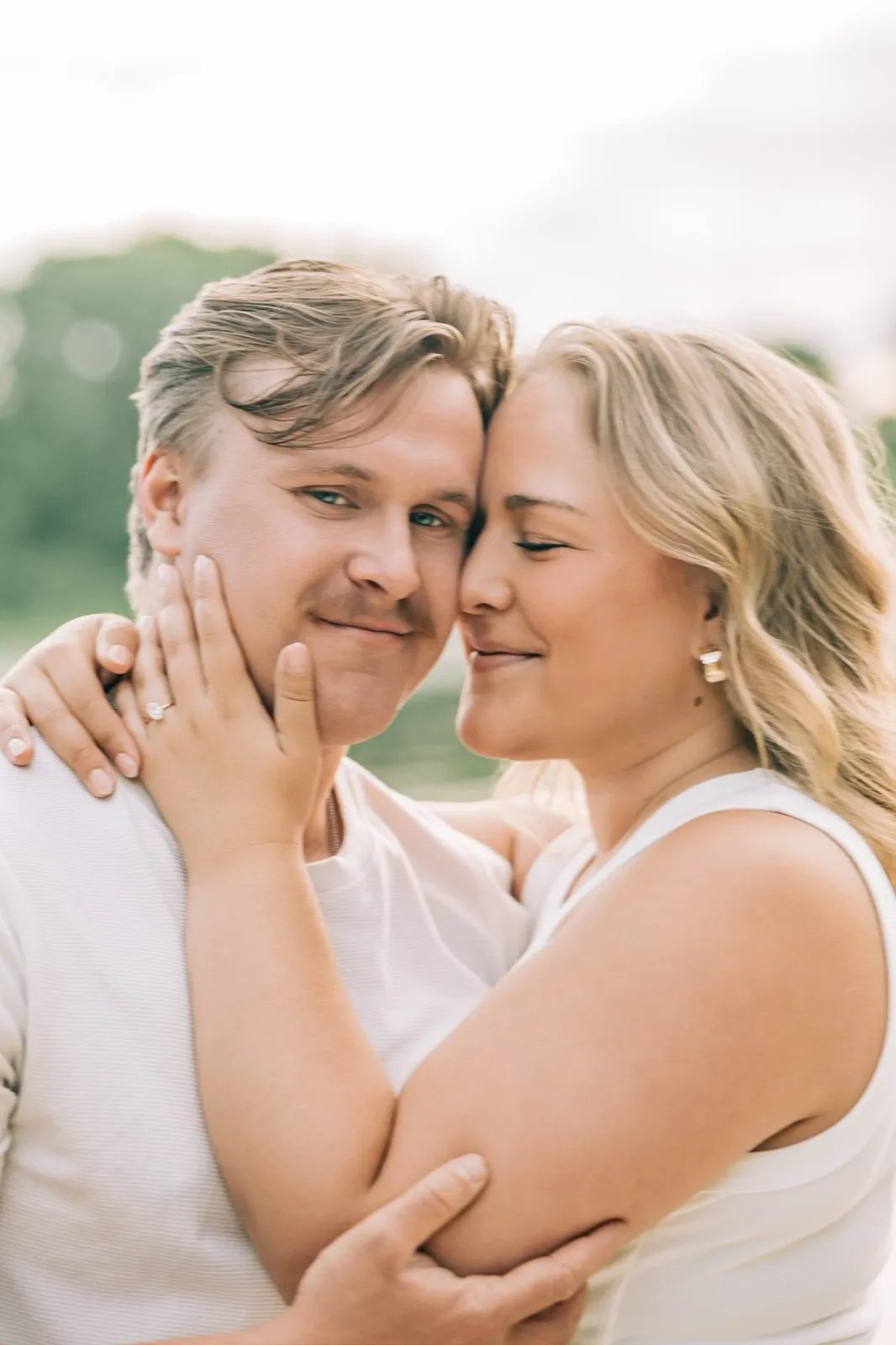 Abby and Anthony stand close on the Lake Auburn dock, smiling at the camera with the lake behind them — Tim Larsen Photography