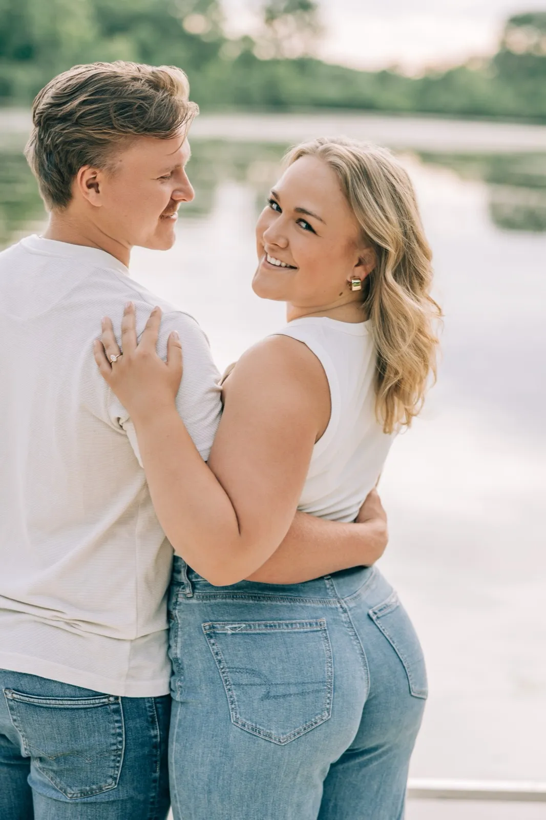 Abby and Anthony smile cheek to cheek on the Lake Auburn dock, the lake calm behind them — Tim Larsen Photography