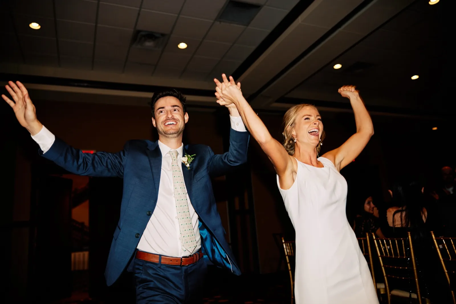 The bride and groom raise their arms and cheer as they make their grand entrance into the Grand View Lodge reception ballroom. — Tim Larsen Photography, Brainerd Lakes MN