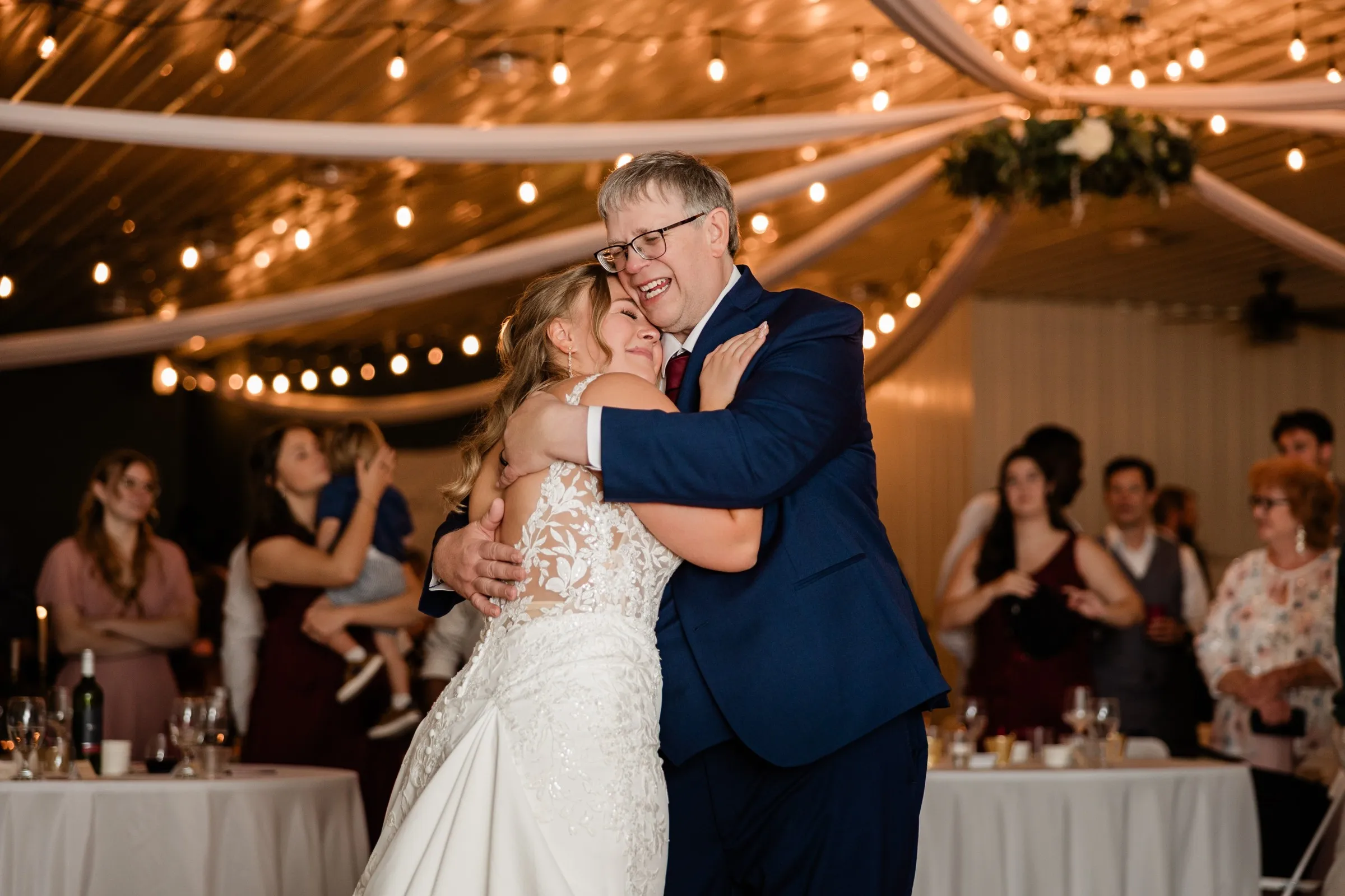 Abby closes her eyes and embraces her dad, Kyle, on the dance floor as guests watch at The Gathering in Crosslake — Tim Larsen Photography, Brainerd Lakes MN