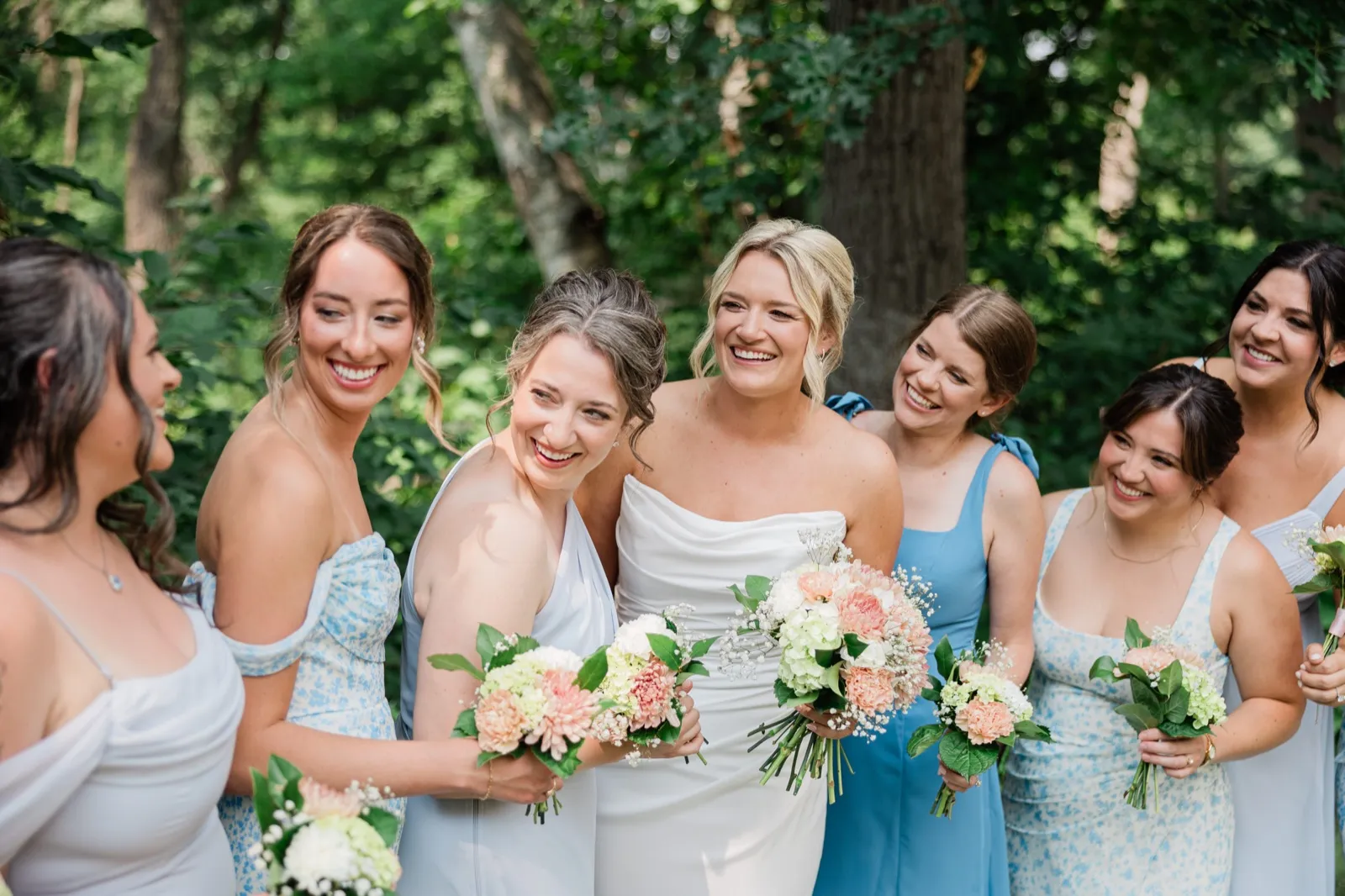 Amy laughs with her friends in pastel blue dresses on a wooded path behind Whitefish Lodge — Tim Larsen Photography, Brainerd Lakes MN