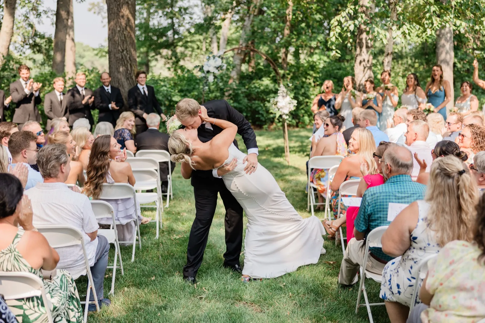 Carter dips Amy for a kiss in the middle of the aisle at Whitefish Lodge while the entire seated crowd applauds — Tim Larsen Photography, Brainerd Lakes MN