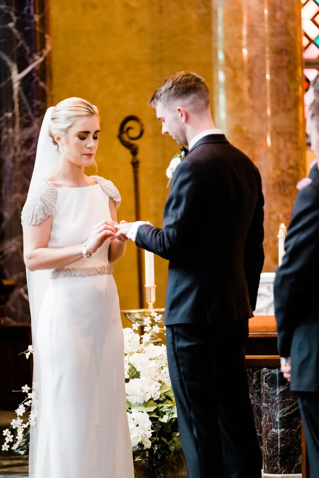 Bride centered with veil falling, groom in profile placing the ring during their quiet vow exchange — Cathedral of Our Lady of the Rosary ceremony — Tim Larsen Photography, Duluth MN