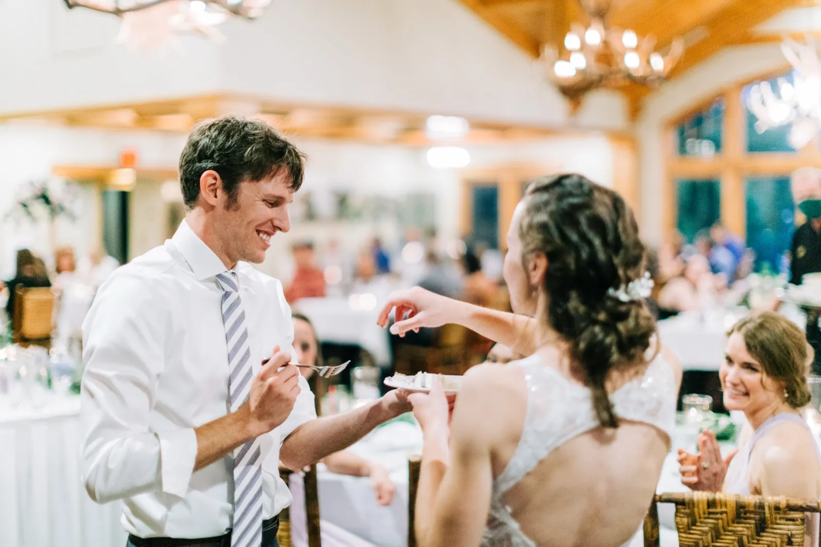 Brenden laughs as Katie reaches toward him with a fork during the cake cutting at Madden's on Gull Lake — Tim Larsen Photography, Brainerd Lakes MN