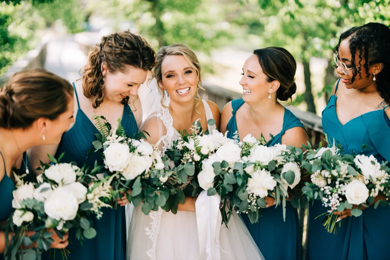 Hailee laughs surrounded by her bridesmaids in teal on a tree-lined path at Madden's — Tim Larsen Photography, Brainerd Lakes MN