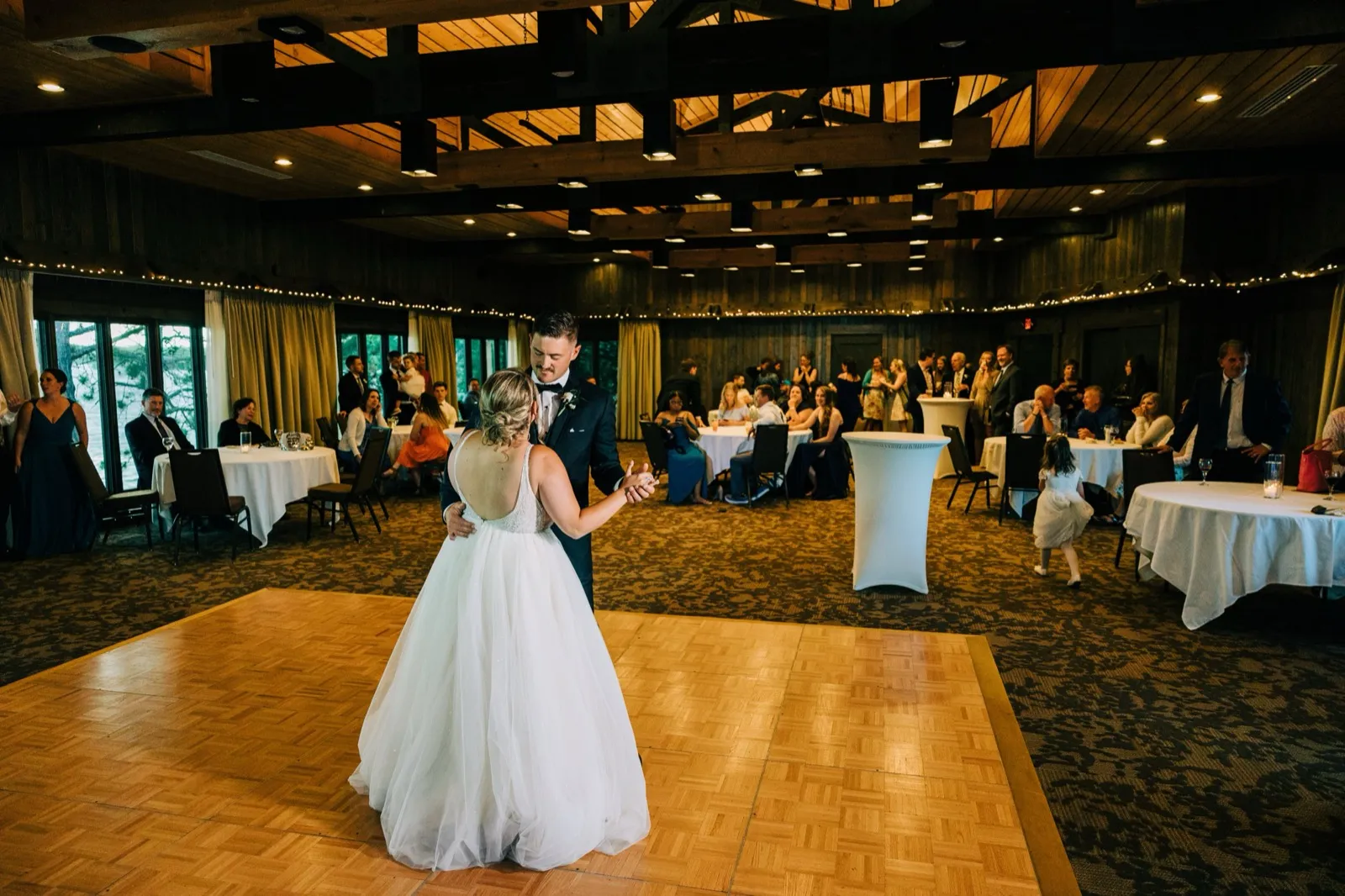 Hailee and Jonathon dance alone on the parquet floor of the timber-beamed ballroom as guests watch from the tables at Madden's — Tim Larsen Photography, Brainerd Lakes MN