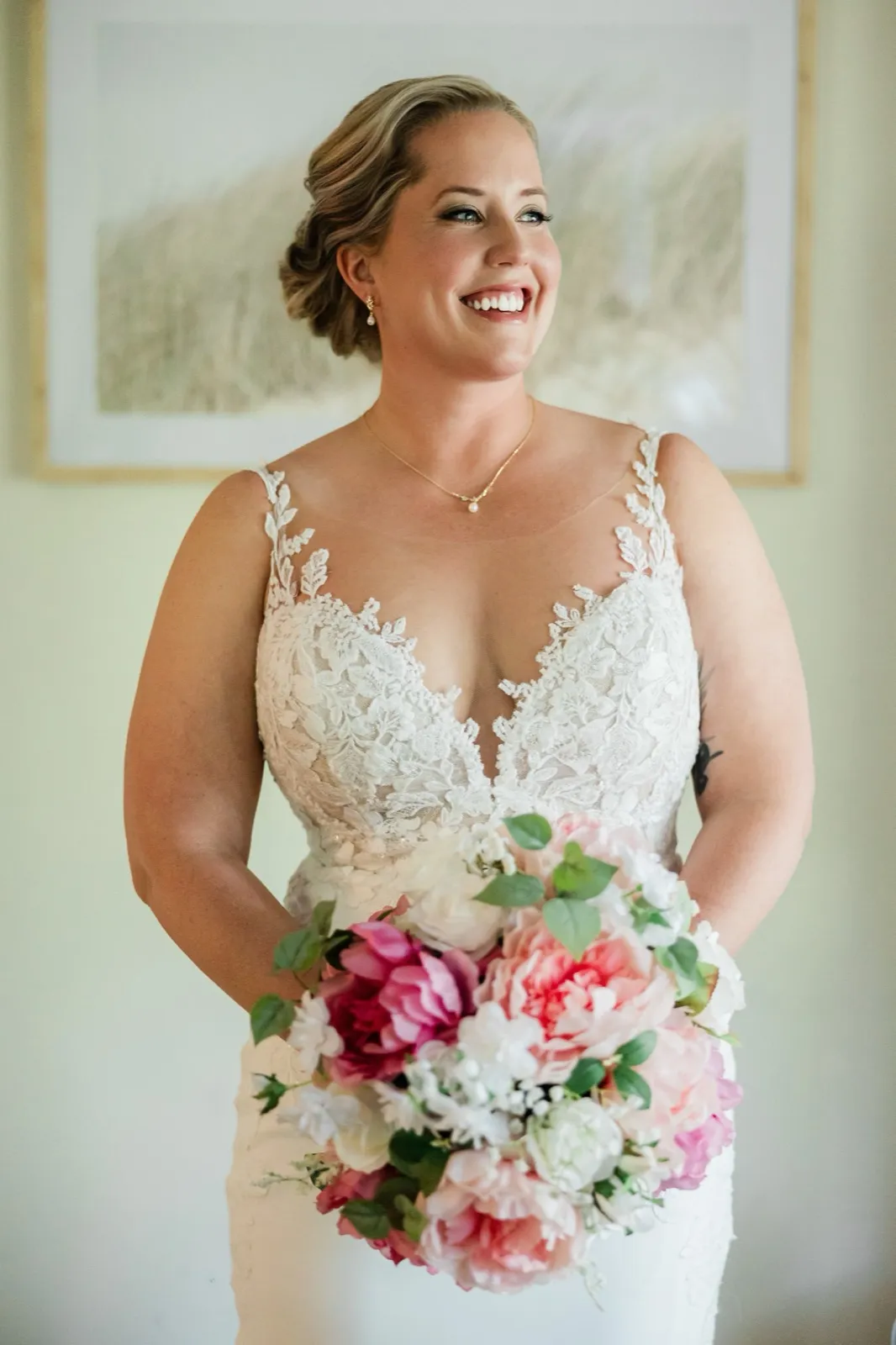 The bride laughs looking off-camera in soft window light, bouquet in hand — Tim Larsen Photography, Brainerd Lakes MN