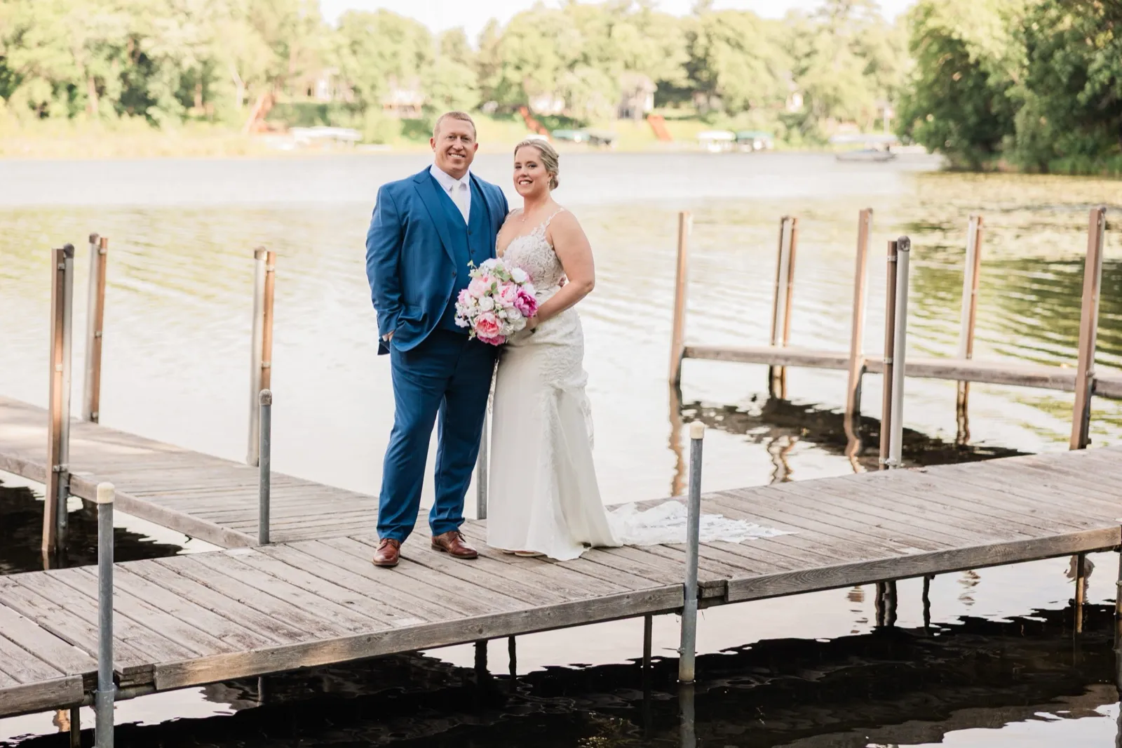 Lauren and Jeremy stand smiling together on the dock over calm water at Lost Lake Lodge near Nisswa — Tim Larsen Photography, Brainerd Lakes MN