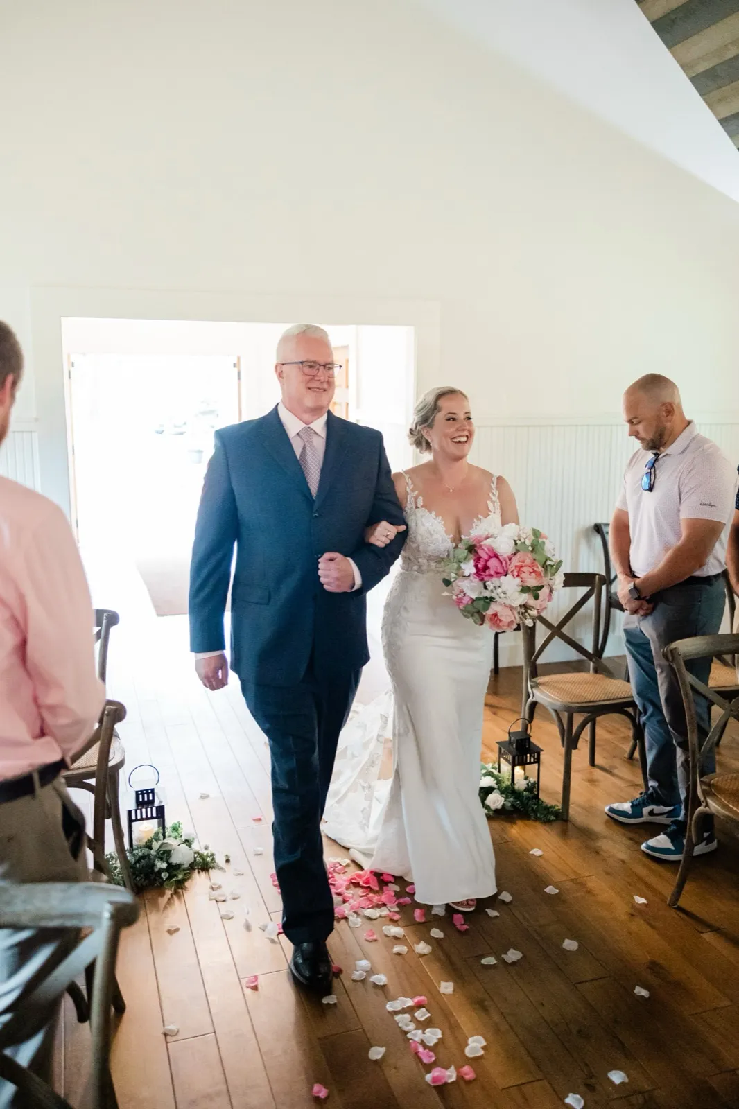 Lauren laughs on her father's arm as they walk the petal-strewn aisle of The Chapel at Grand View Lodge — Tim Larsen Photography, Brainerd Lakes MN