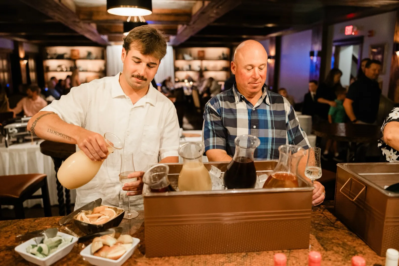 A guest pours juice from a carafe at the build-your-own mimosa bar during the brunch reception at Cru — Tim Larsen Photography, Brainerd Lakes MN