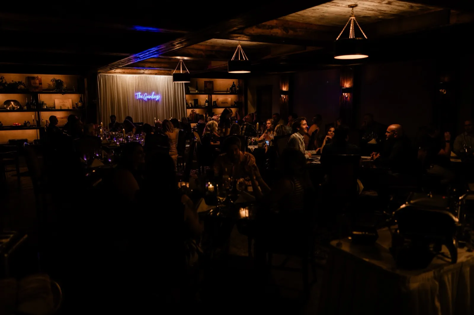 Cru, the candlelit wine-cellar restaurant at Grand View Lodge, set for the brunch reception with a neon sign reading 'The Gardings' on the draped wall — Tim Larsen Photography, Brainerd Lakes MN