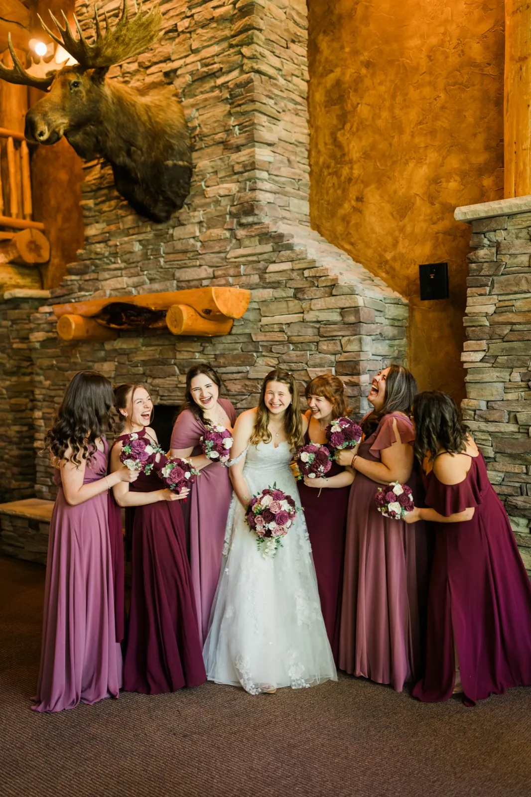 Maddie and her bridesmaids gather in front of the stone fireplace at Whitefish Lodge — Tim Larsen Photography, Brainerd Lakes MN
