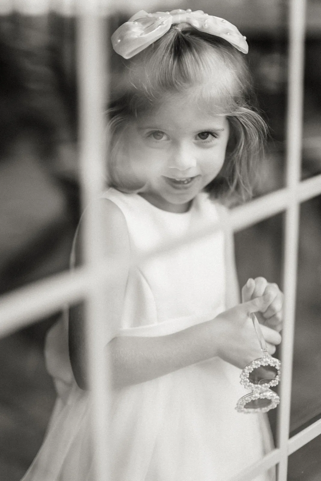 A young girl looks through a window with sunglasses resting on her head — Tim Larsen Photography, Brainerd Lakes MN