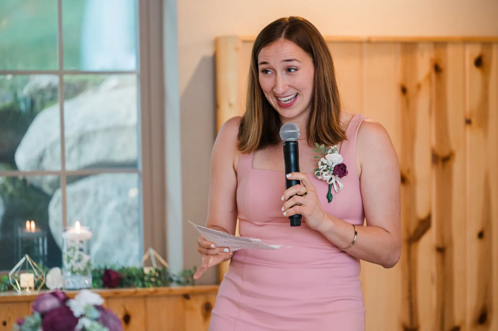 A woman in a pink dress speaks into a microphone during the wedding toasts — Tim Larsen Photography, Brainerd Lakes MN