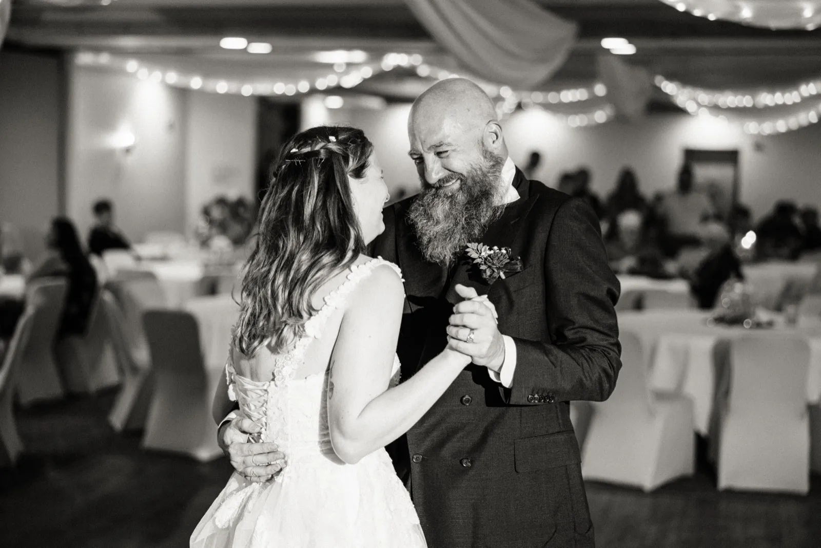 Maddie dances with her dad beneath the reception string lights — Tim Larsen Photography, Brainerd Lakes MN