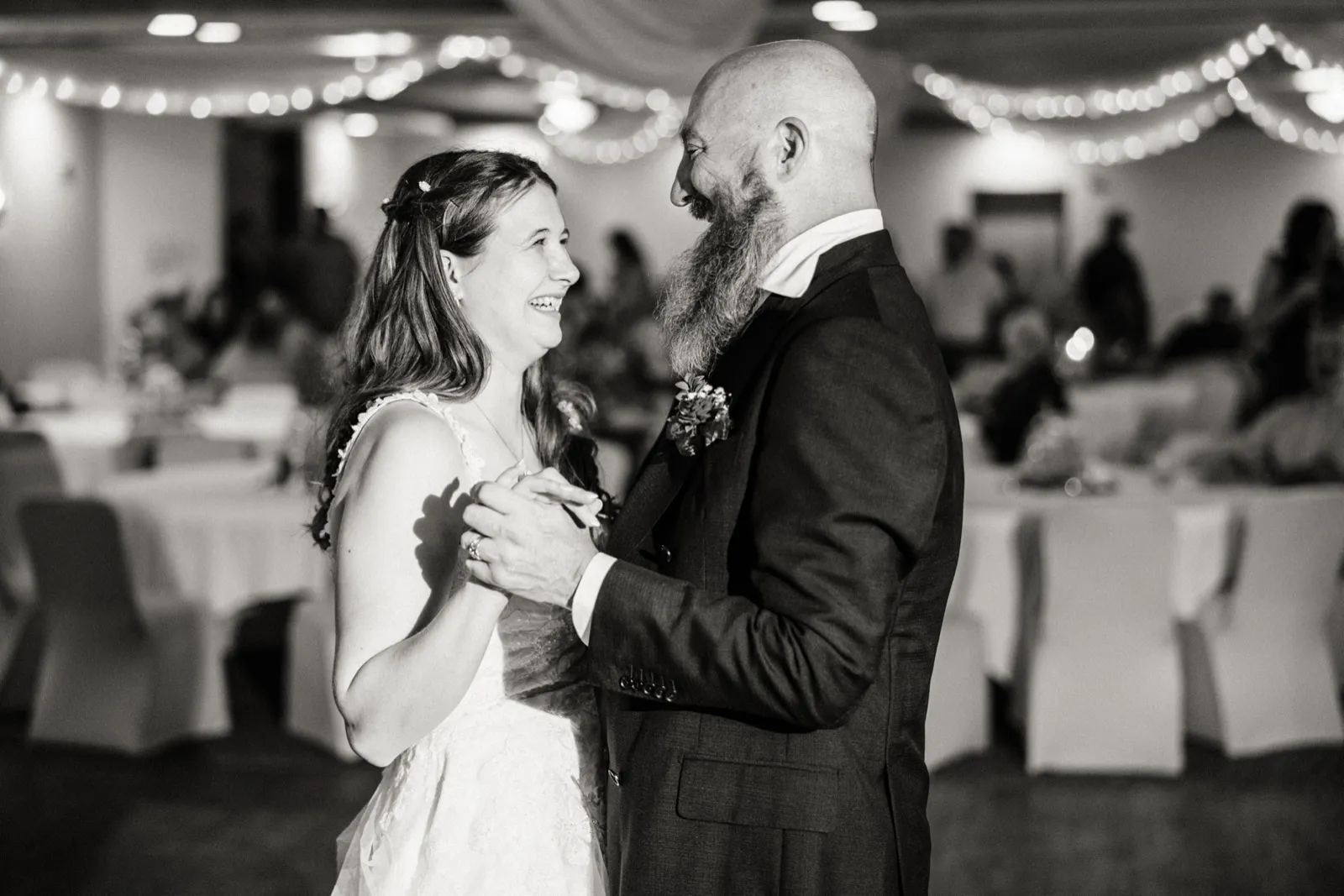 Maddie laughs while dancing with her dad in a black-and-white photograph — Tim Larsen Photography, Brainerd Lakes MN