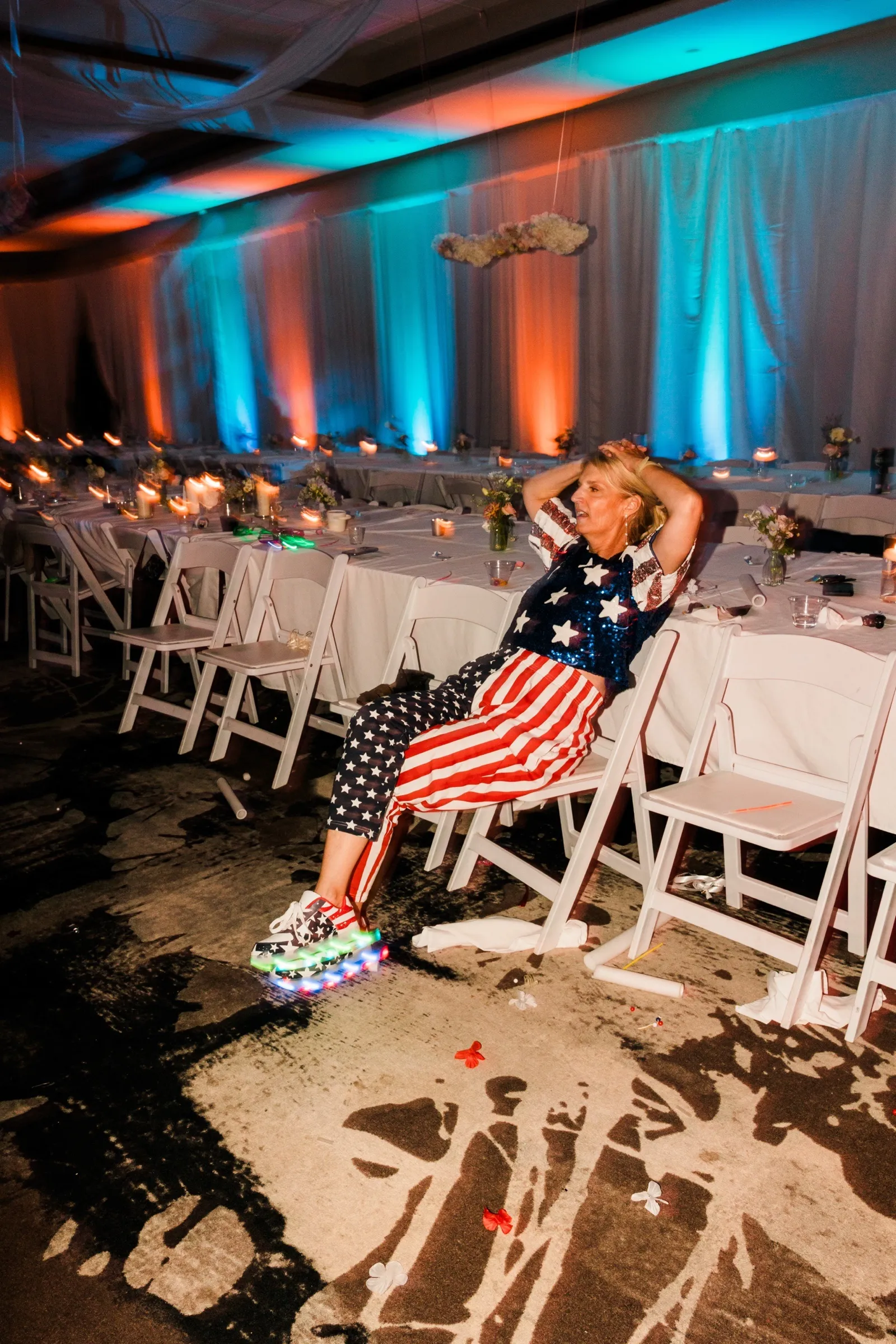 A guest in sequined stars and stripes and light-up sneakers rests in a folding chair at the end of the night — Tim Larsen Photography, Brainerd Lakes MN