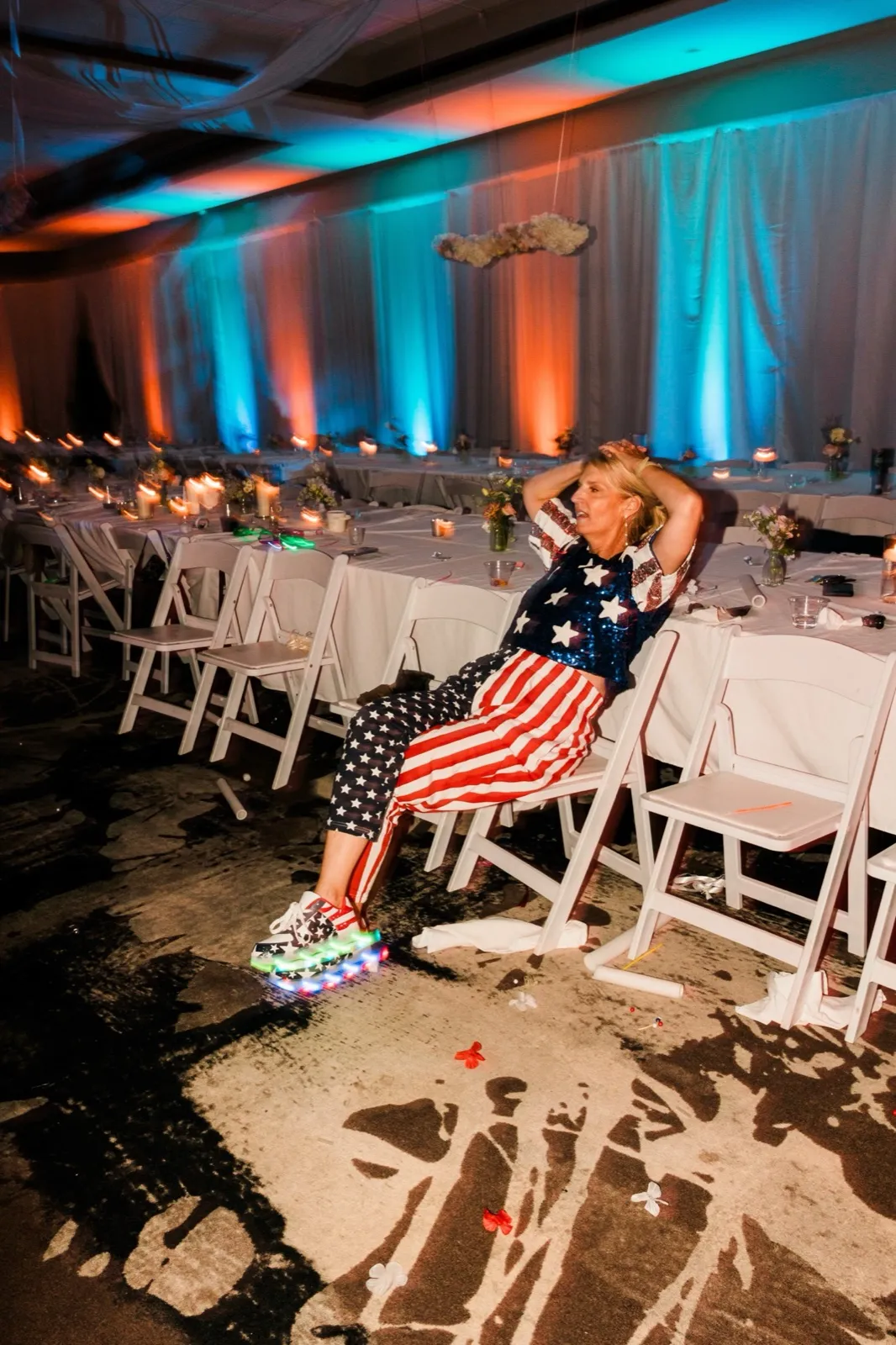 A guest in sequined stars and stripes and light-up sneakers rests in a folding chair at the end of the night — Tim Larsen Photography, Brainerd Lakes MN