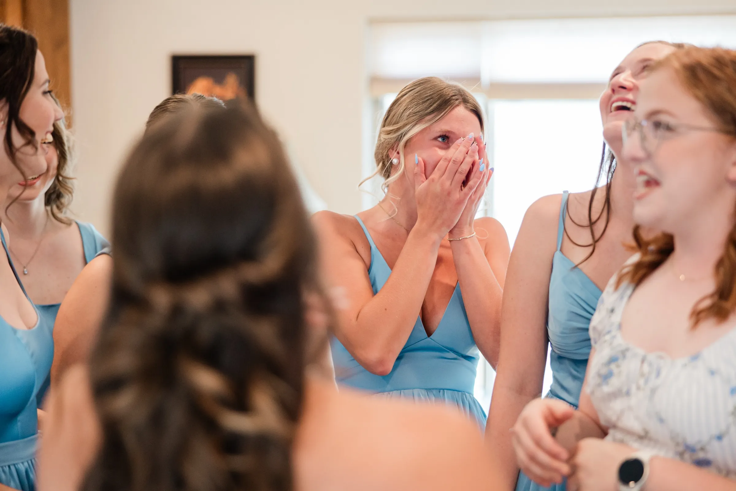A bridesmaid presses both hands to her face with wet eyes while the bridesmaids around her laugh at the bride's reveal — Tim Larsen Photography, Brainerd Lakes MN