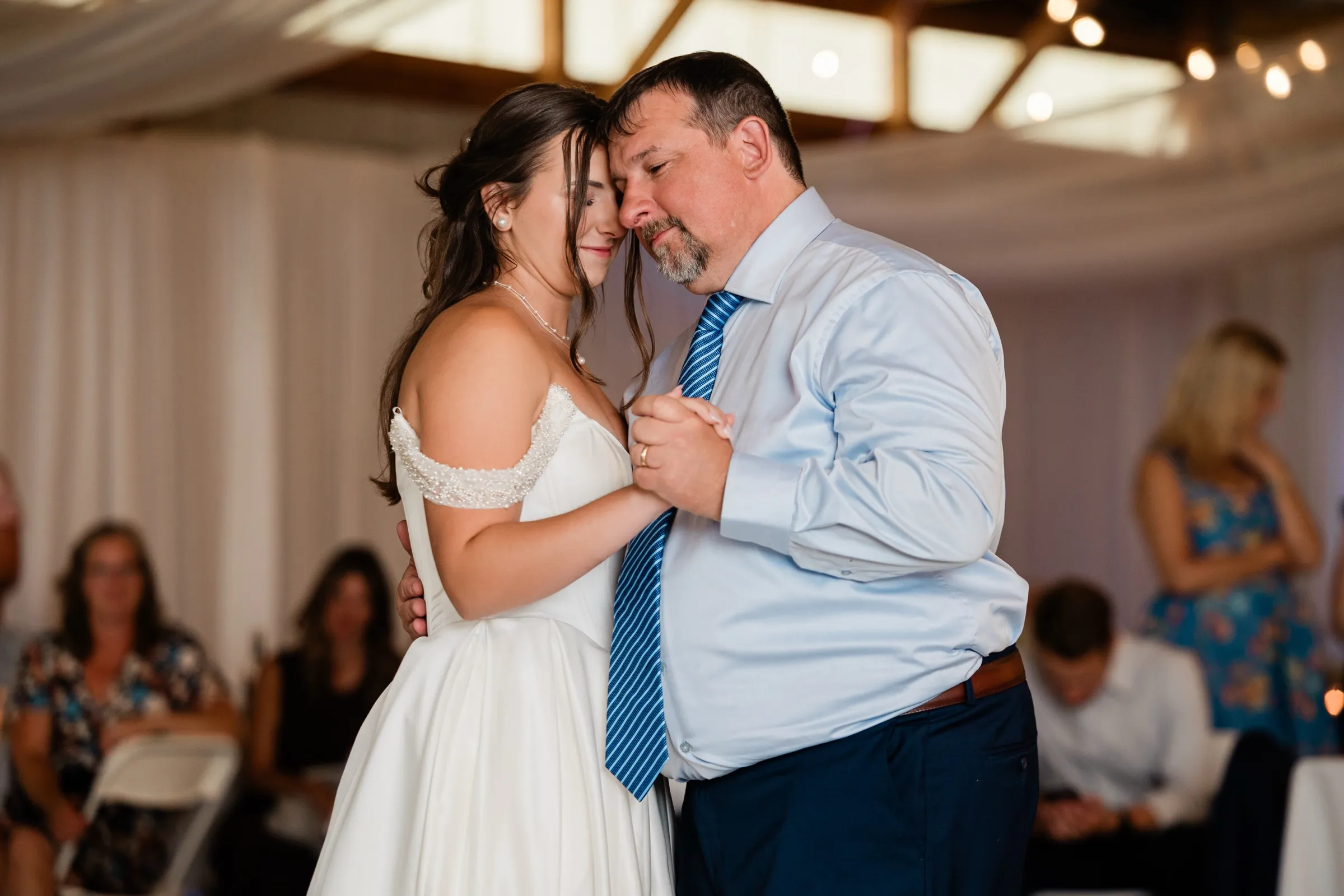 The bride and her father dance with foreheads together and eyes closed in the draped pole-barn hall — Tim Larsen Photography, Brainerd Lakes MN