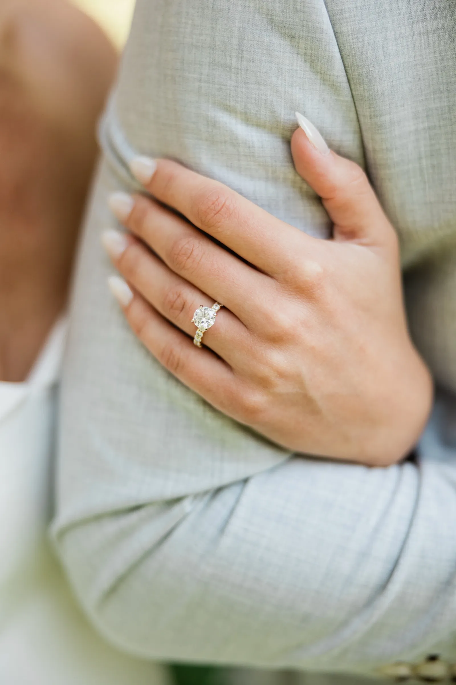 Josse's hand rests on the sleeve of Alex's gray suit, her engagement ring visible — Tim Larsen Photography, Brainerd Lakes MN