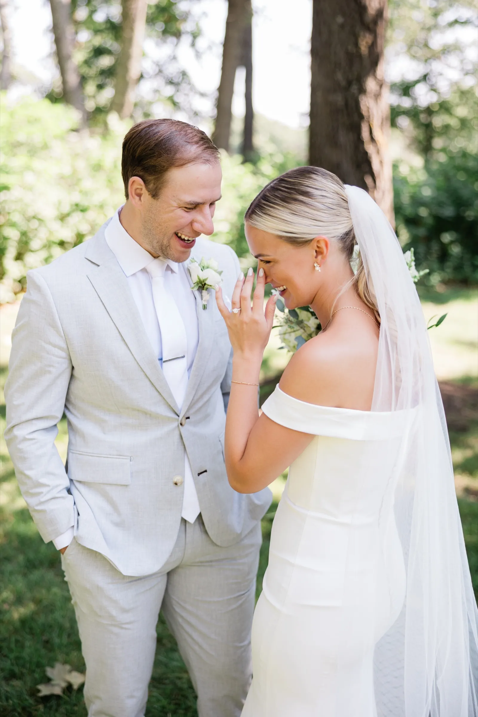 Josse covers her face with her hand as she and Alex laugh together under the pines — Tim Larsen Photography, Brainerd Lakes MN