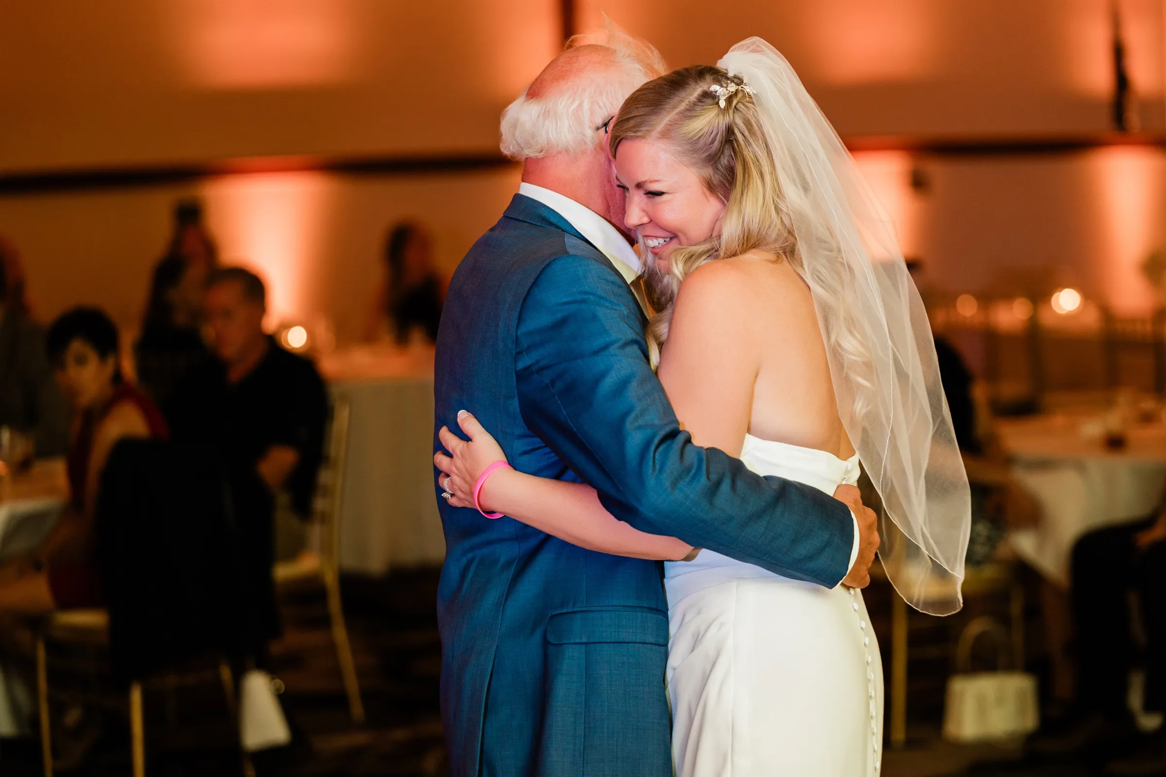 The bride presses her face into her father's shoulder during their dance, her veil falling across her back. — Tim Larsen Photography, Brainerd Lakes MN