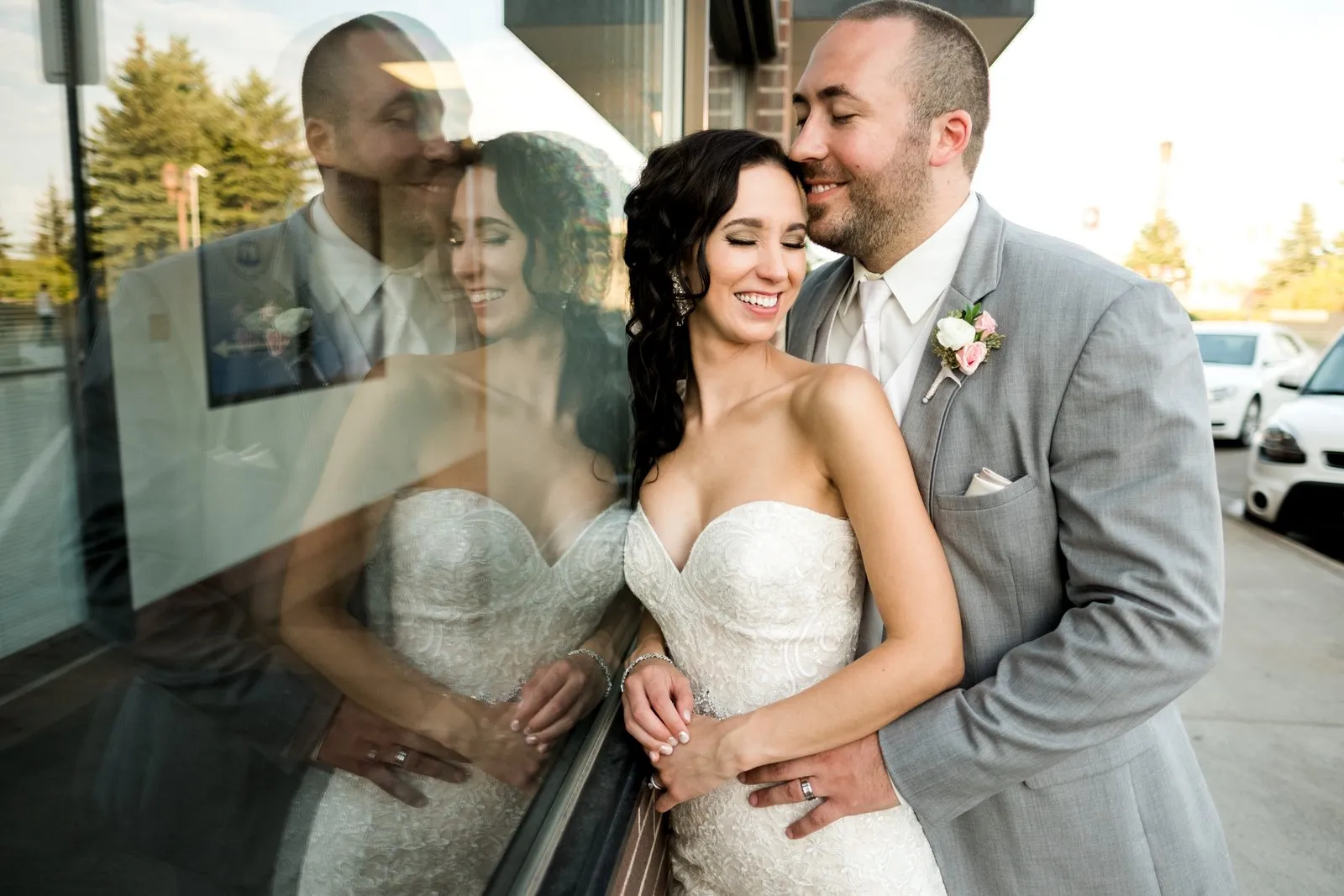 Couple pressed against a downtown Duluth storefront window with a full mirrored reflection doubling the frame — autumn wedding portrait — Tim Larsen Photography, Duluth MN