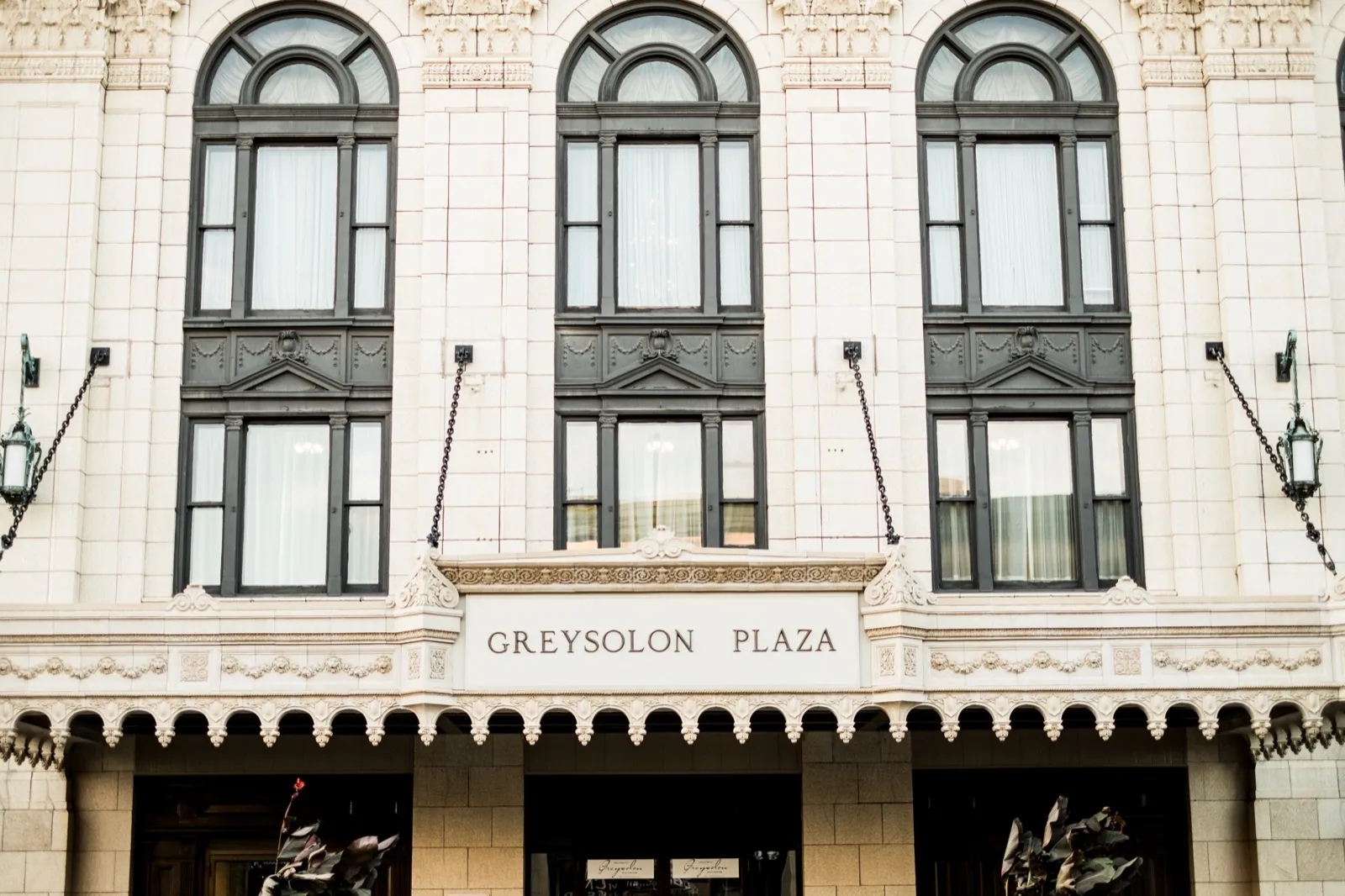 Greysolon Plaza exterior — symmetrical historic facade with arched windows above the engraved Greysolon Plaza entrance sign in downtown Duluth — Tim Larsen Photography, Duluth MN