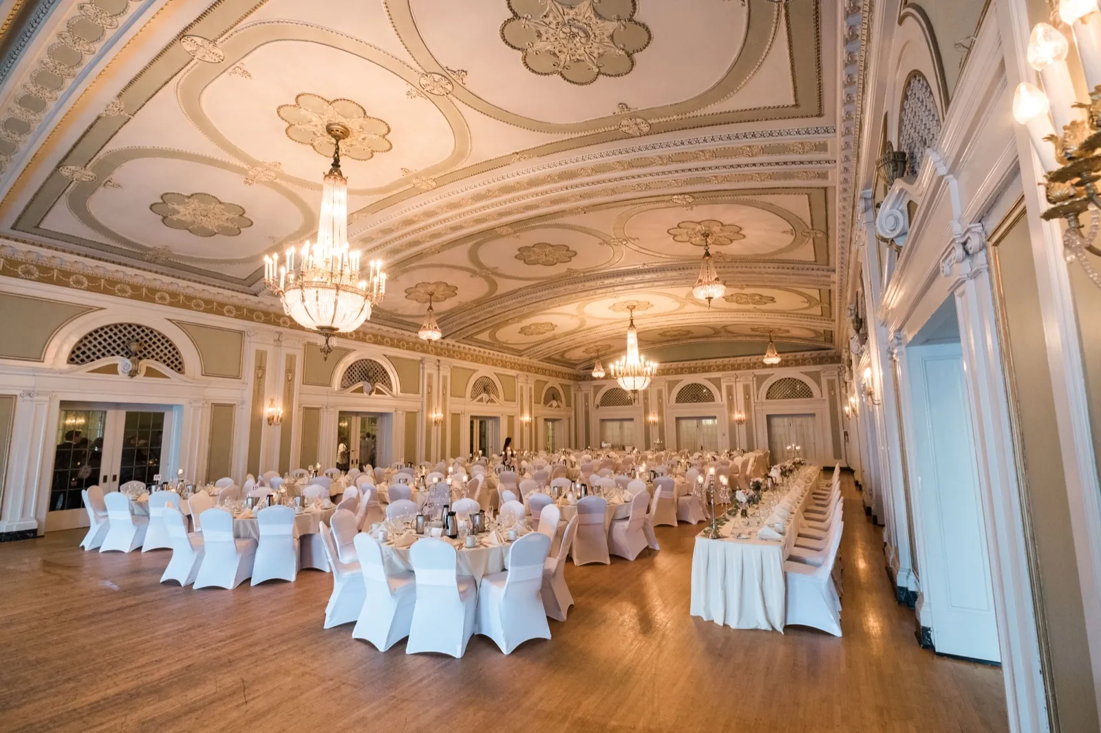 Ultra-wide view of the Greysolon Ballroom flipped for the reception — ornate coffered ceiling and crystal chandeliers above set tables filling the historic 1925 Hotel Duluth ballroom — Tim Larsen Photography, Duluth MN