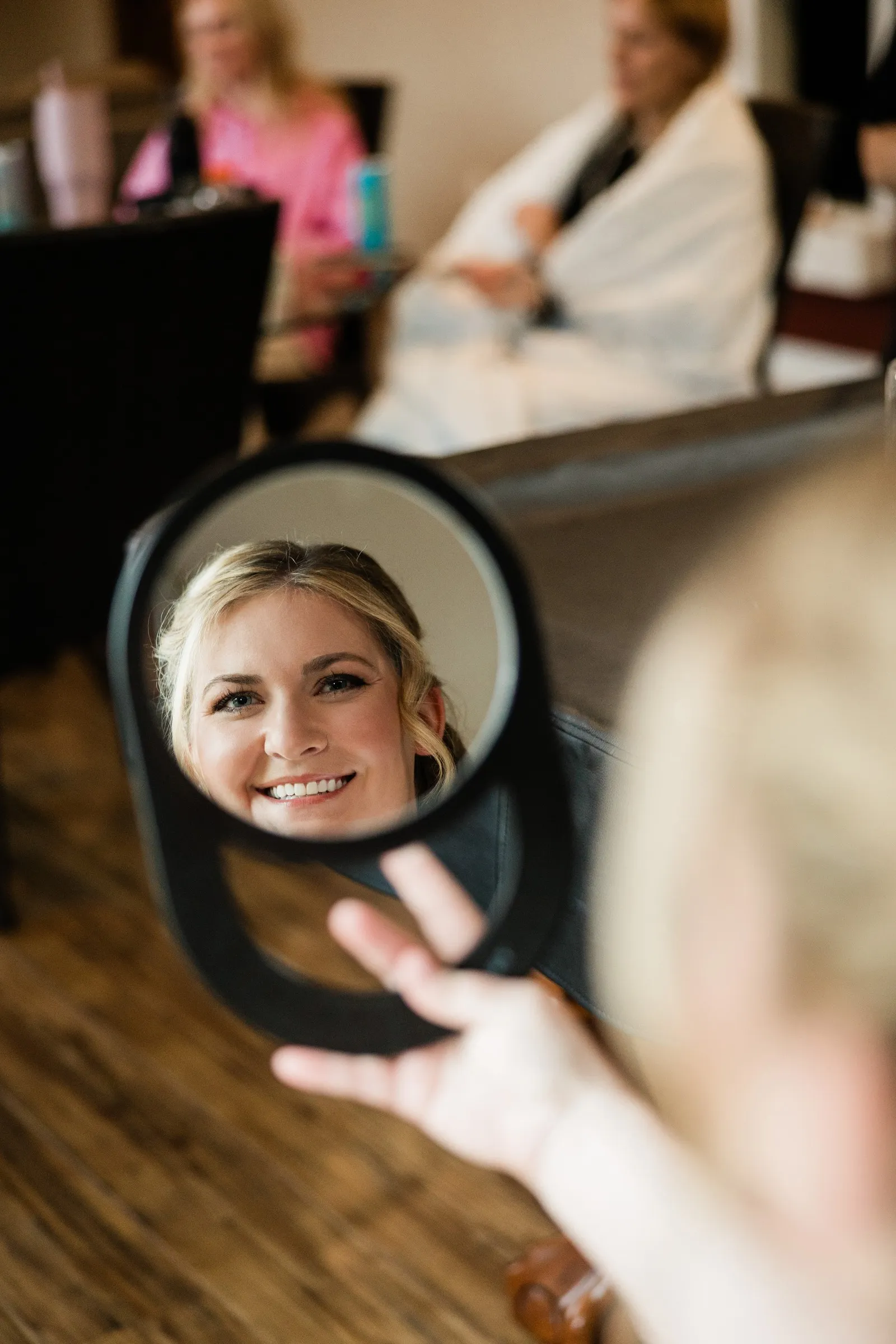 Lauren smiles into a handheld mirror while getting ready in the Garden Cottages at Grand View Lodge — Tim Larsen Photography, Brainerd Lakes MN