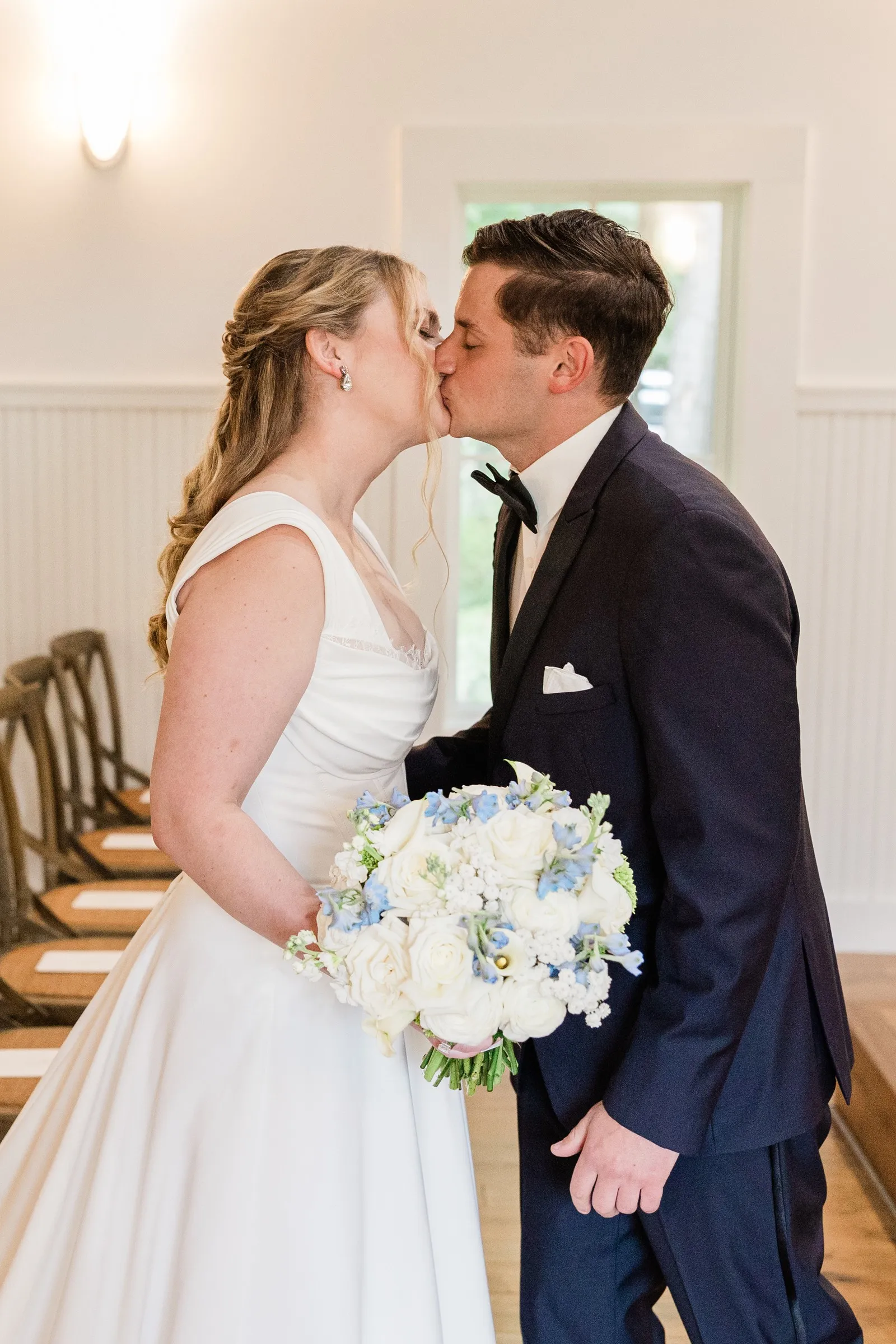 Lauren and Noah kiss during their first look in the Chapel — Tim Larsen Photography, Brainerd Lakes MN