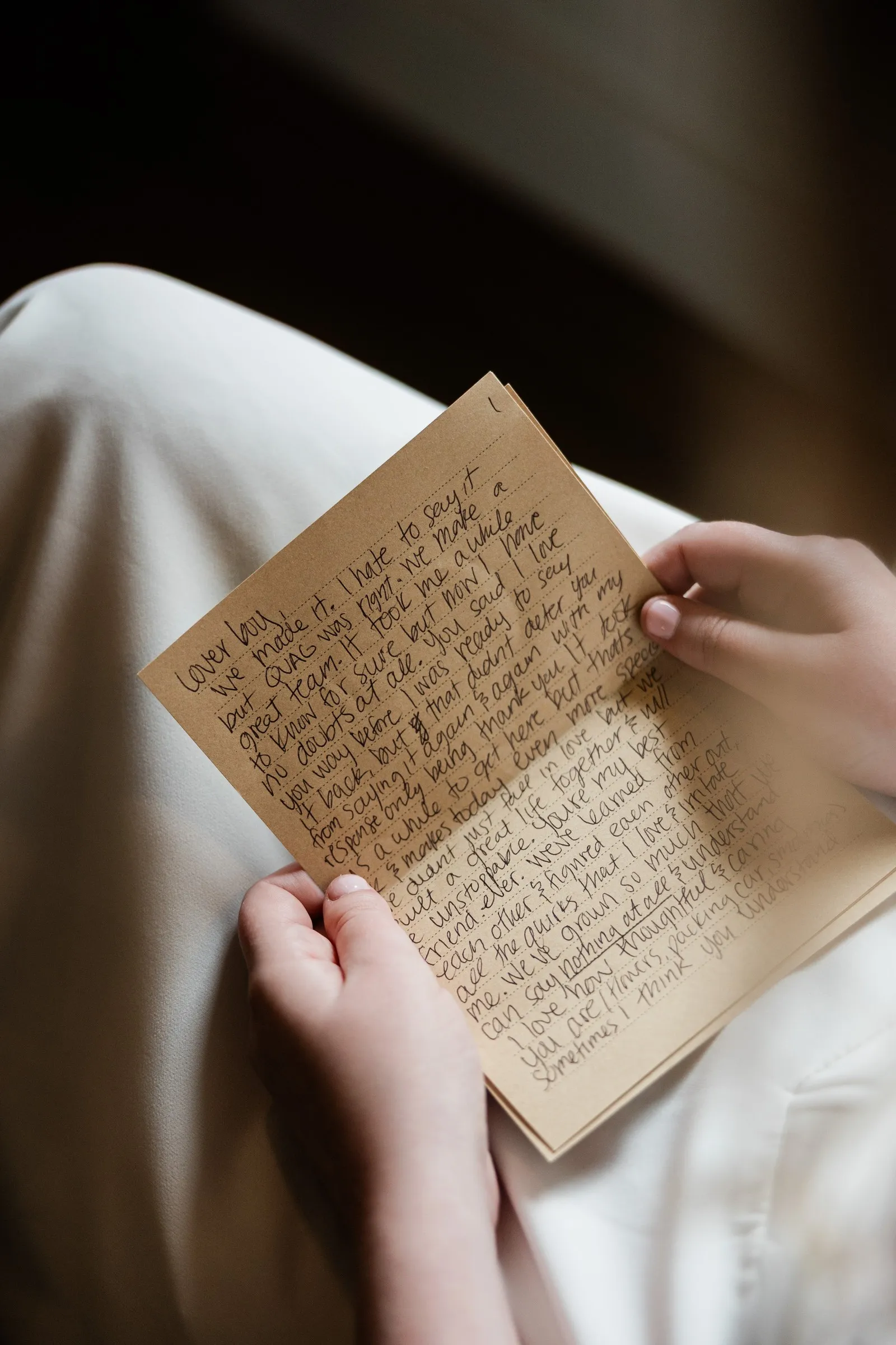 A close view of a handwritten letter held over Lauren’s wedding dress — Tim Larsen Photography, Brainerd Lakes MN