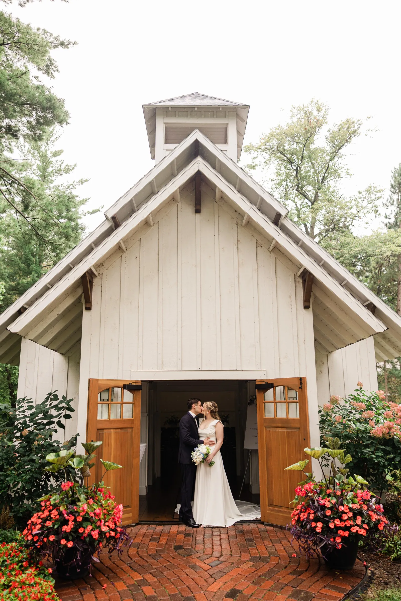 Lauren and Noah stand in the doorway beneath the gabled facade of the Grand View Lodge Chapel — Tim Larsen Photography, Brainerd Lakes MN