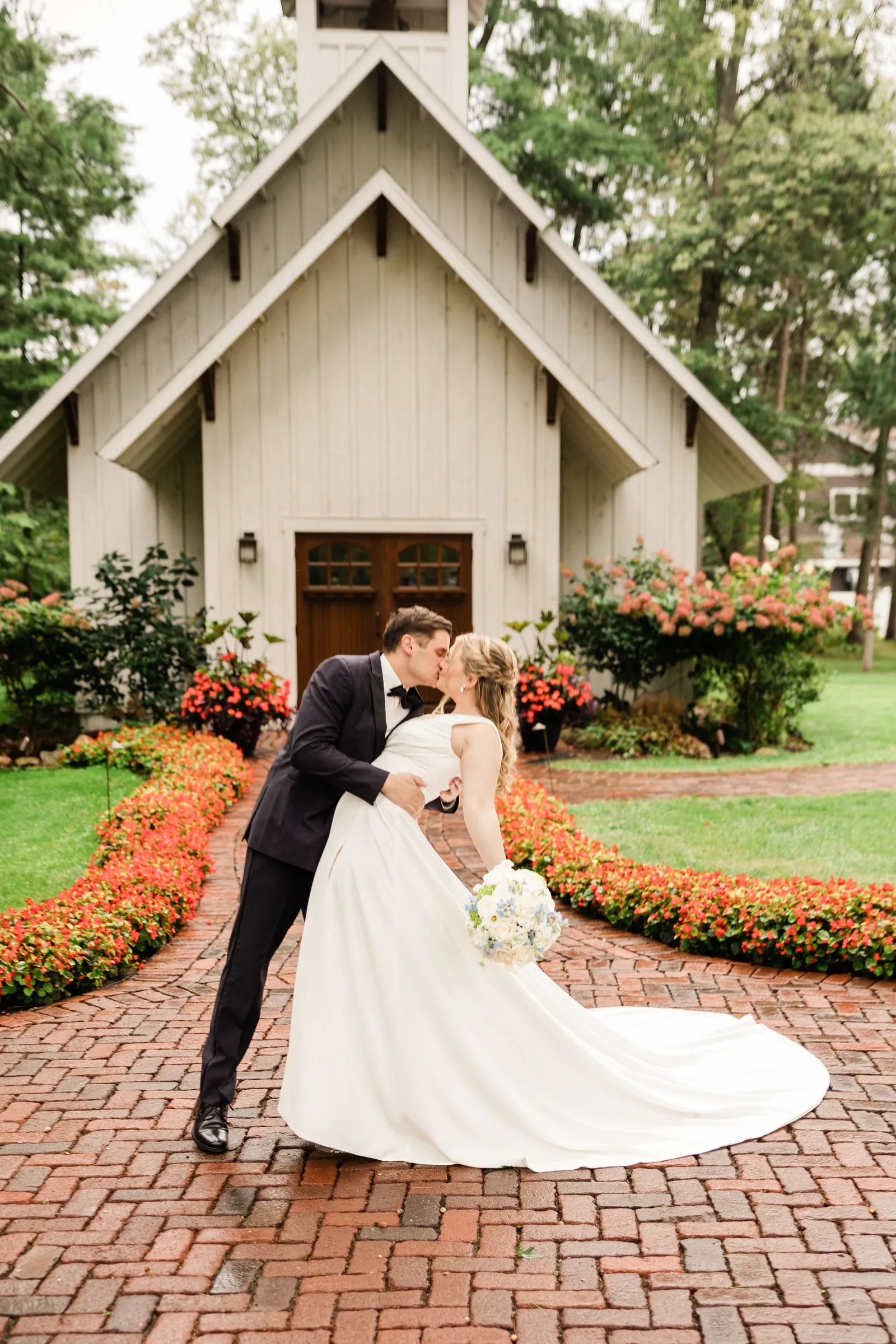 Noah dips Lauren for a kiss on the brick path outside the Grand View Lodge Chapel — Tim Larsen Photography, Brainerd Lakes MN