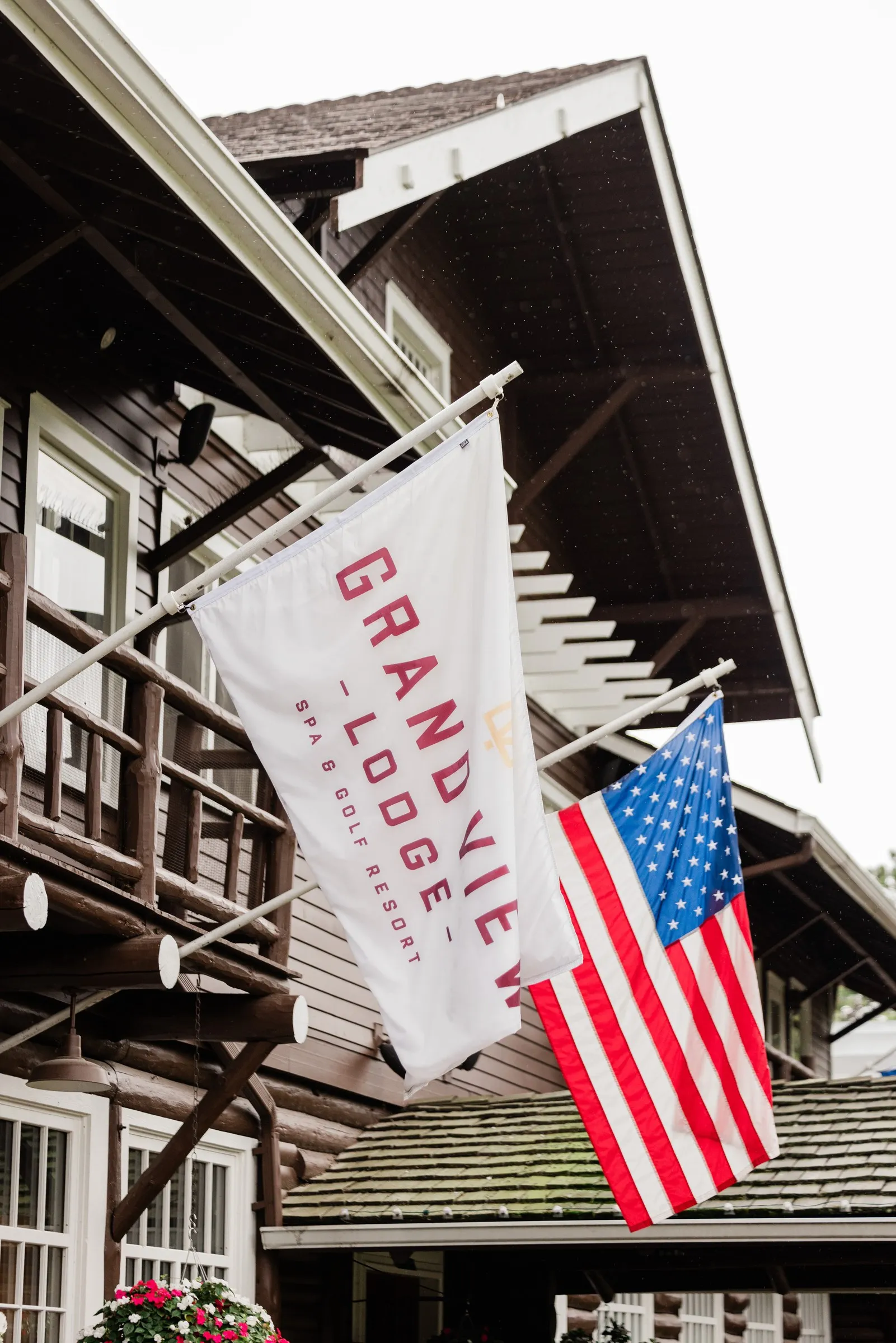 The Grand View Lodge banner and an American flag hang from the timber balcony — Tim Larsen Photography, Brainerd Lakes MN